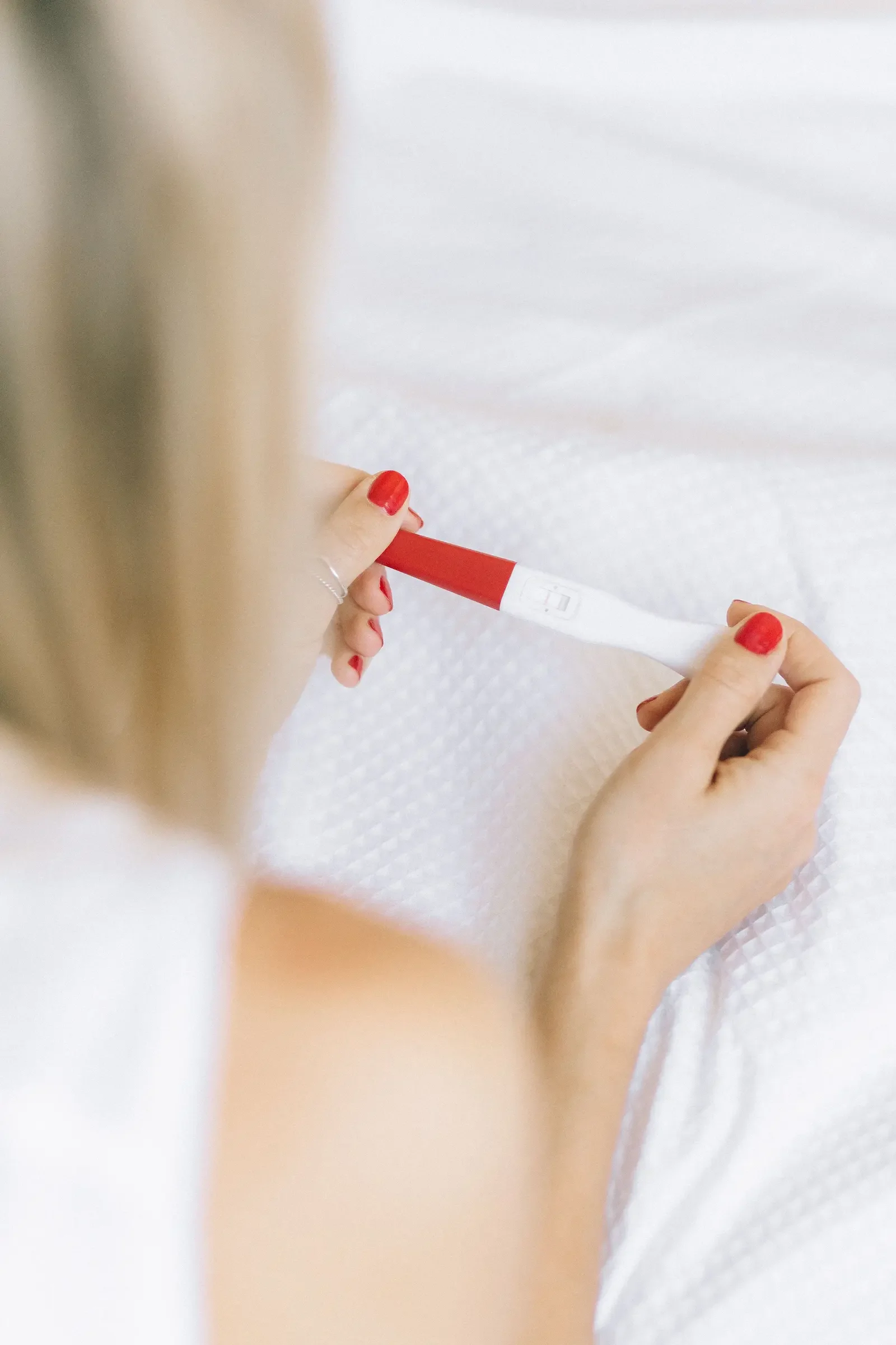 Person holding a positive pregnancy test while planning for pregnancy