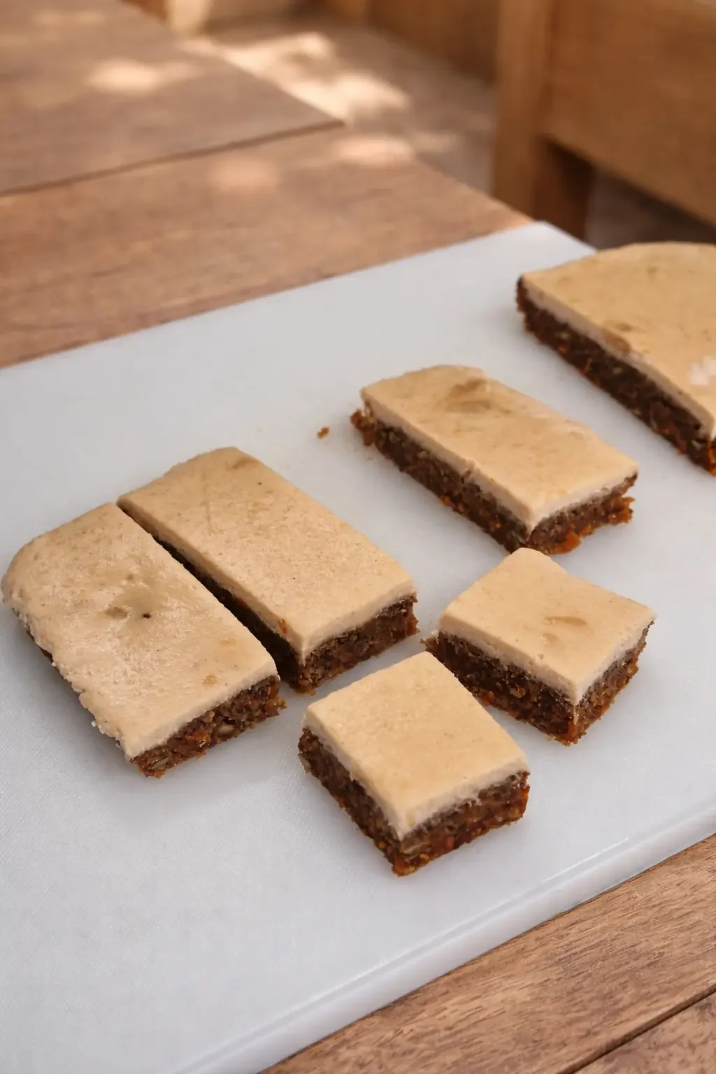 Freshly cut healthy Easter carrot cake bar slice with creamy topping, ready to serve chilled