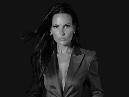 Black and white portrait of a woman with long dark hair wearing a blazer.