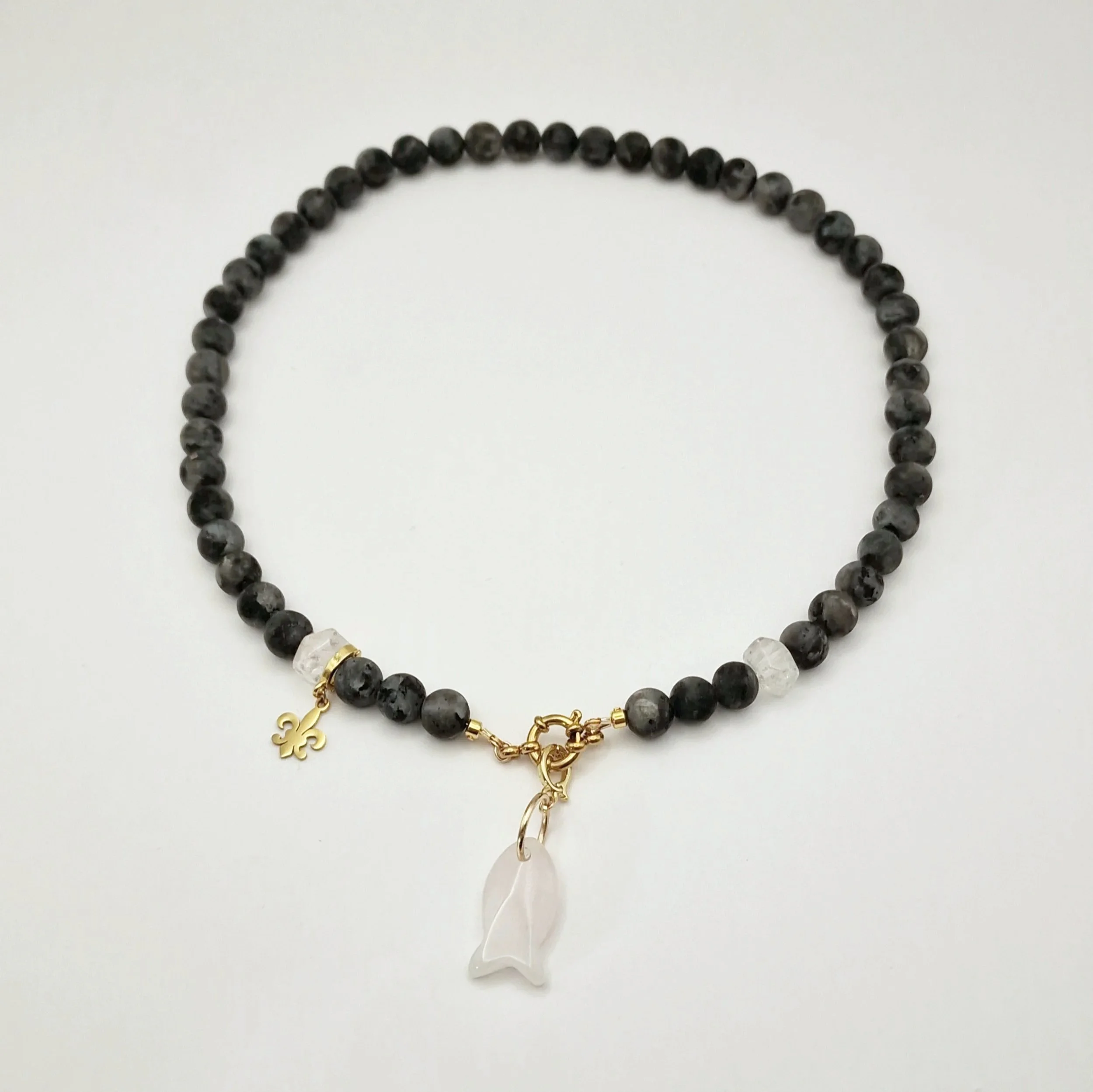 Kette aus Spektrolit, Bergkristall und Rosenquarzanhänger in Fischform mit vergoldetem Verschluss auf hellem Untergrund