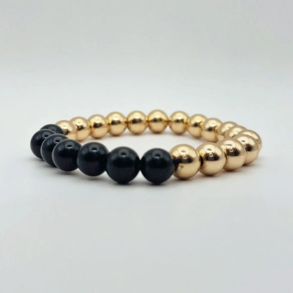 Armband Hekate aus vergoldetem Hämatit und schwarzem glänzenden Onyx auf weißem Untergrund