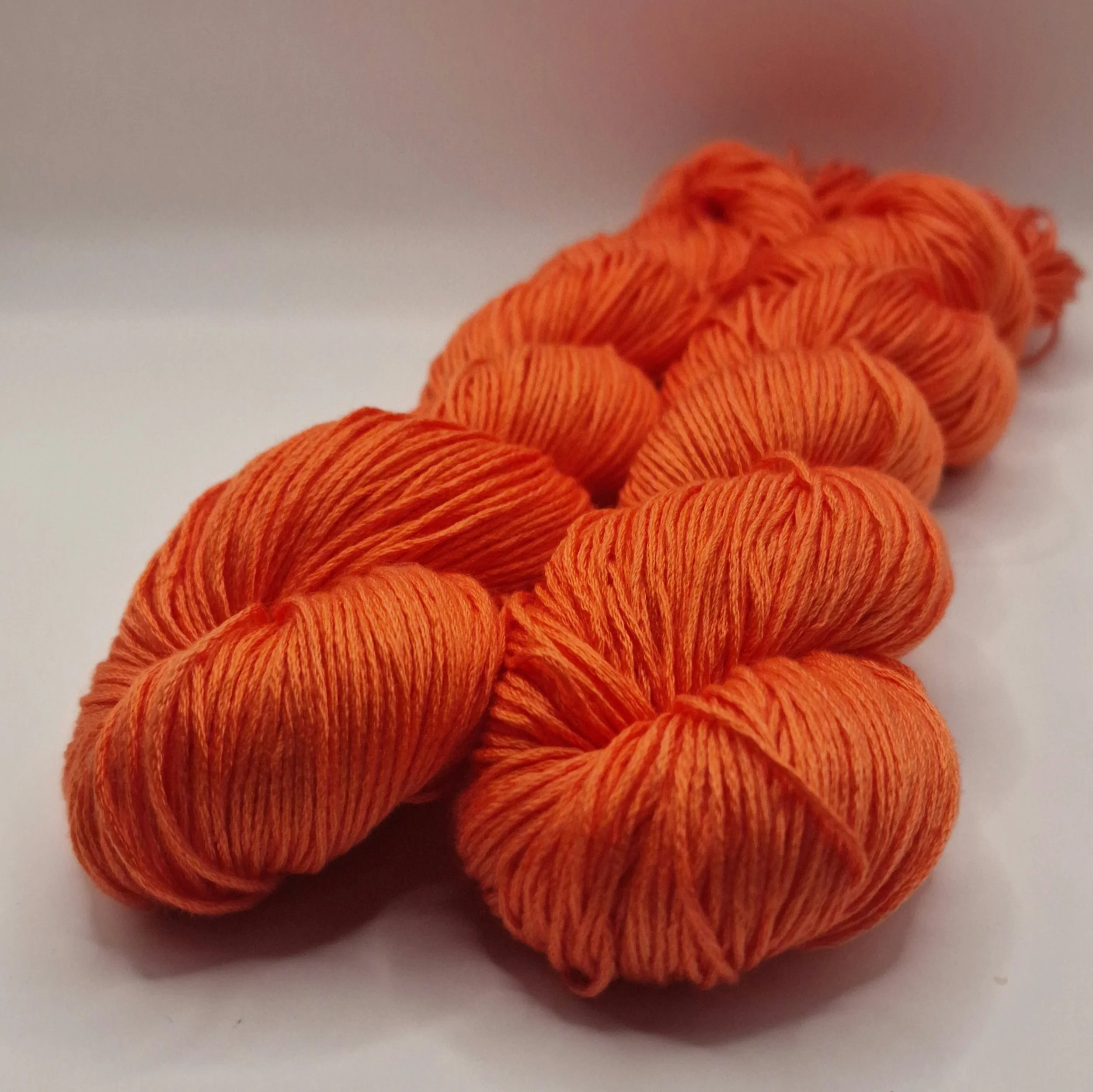 Lyocell Garn zwei Stränge in leuchtendem Orange auf weißem Untergrund
