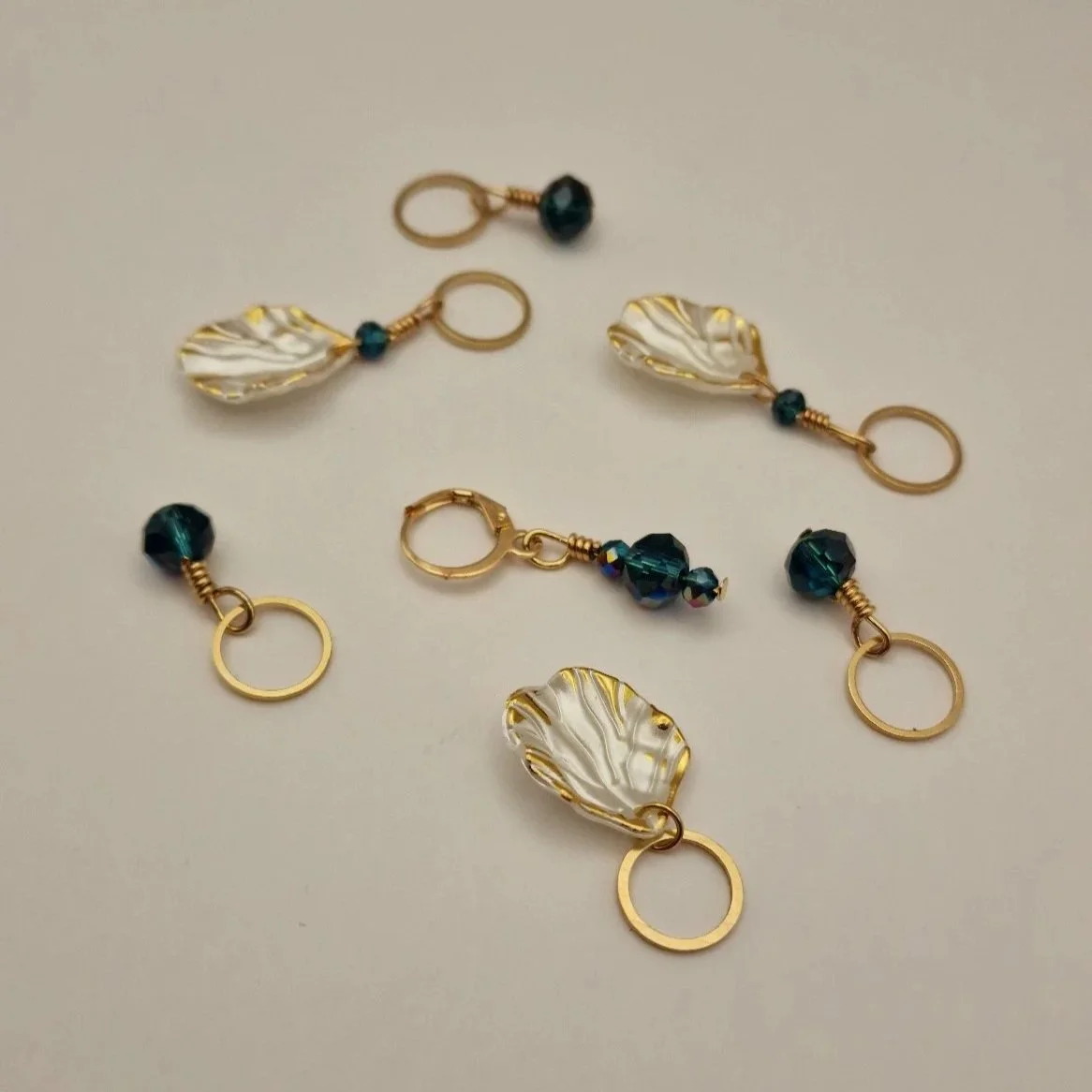 Set aus 6 Maschenmarkierern und einem Progresskeeper in weiß gold und blau auf hellem Untergrund