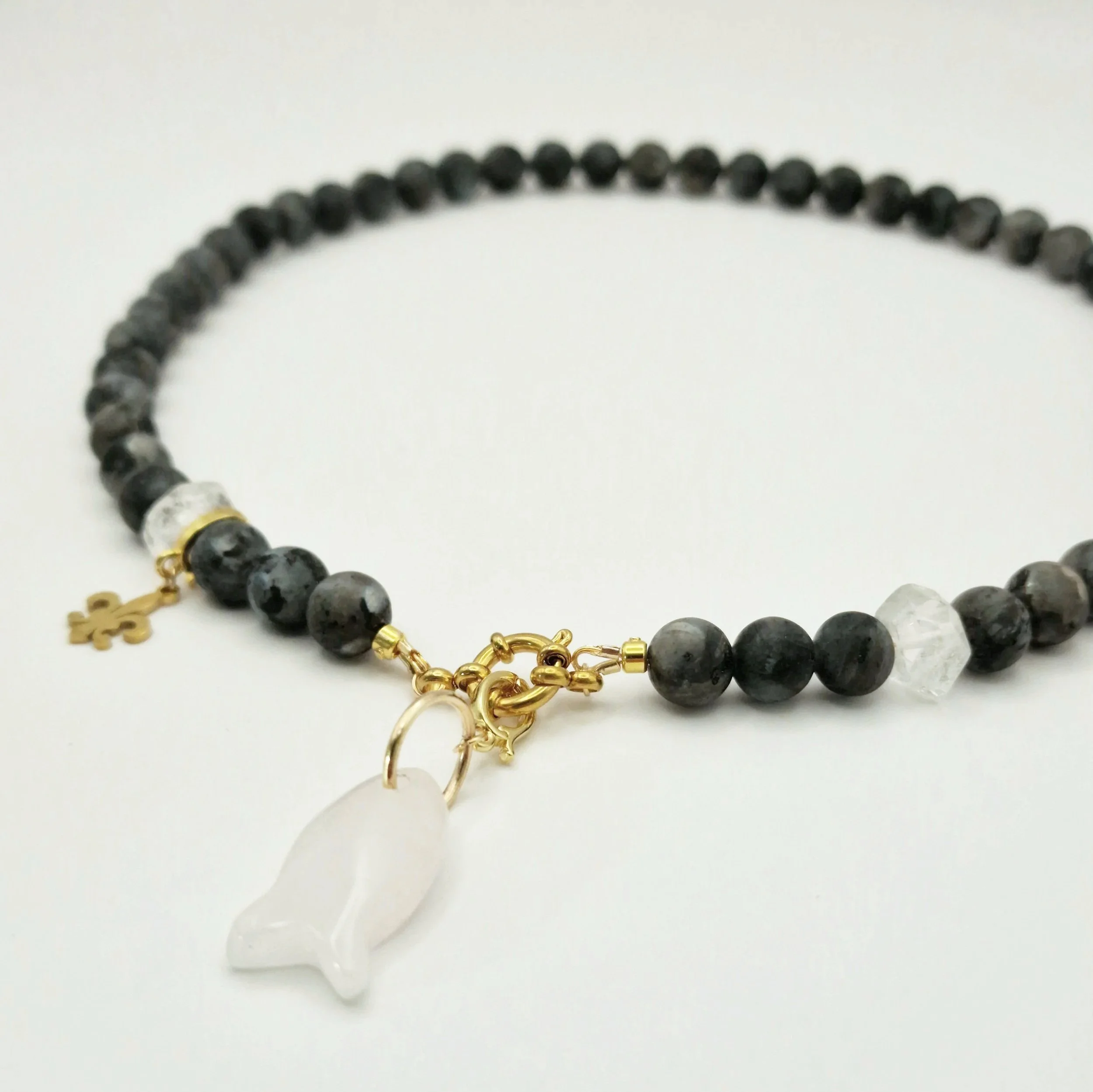 Kette aus Spektrolit, Bergkristall und Rosenquarzanhänger in Fischform mit vergoldetem Verschluss auf hellem Untergrund