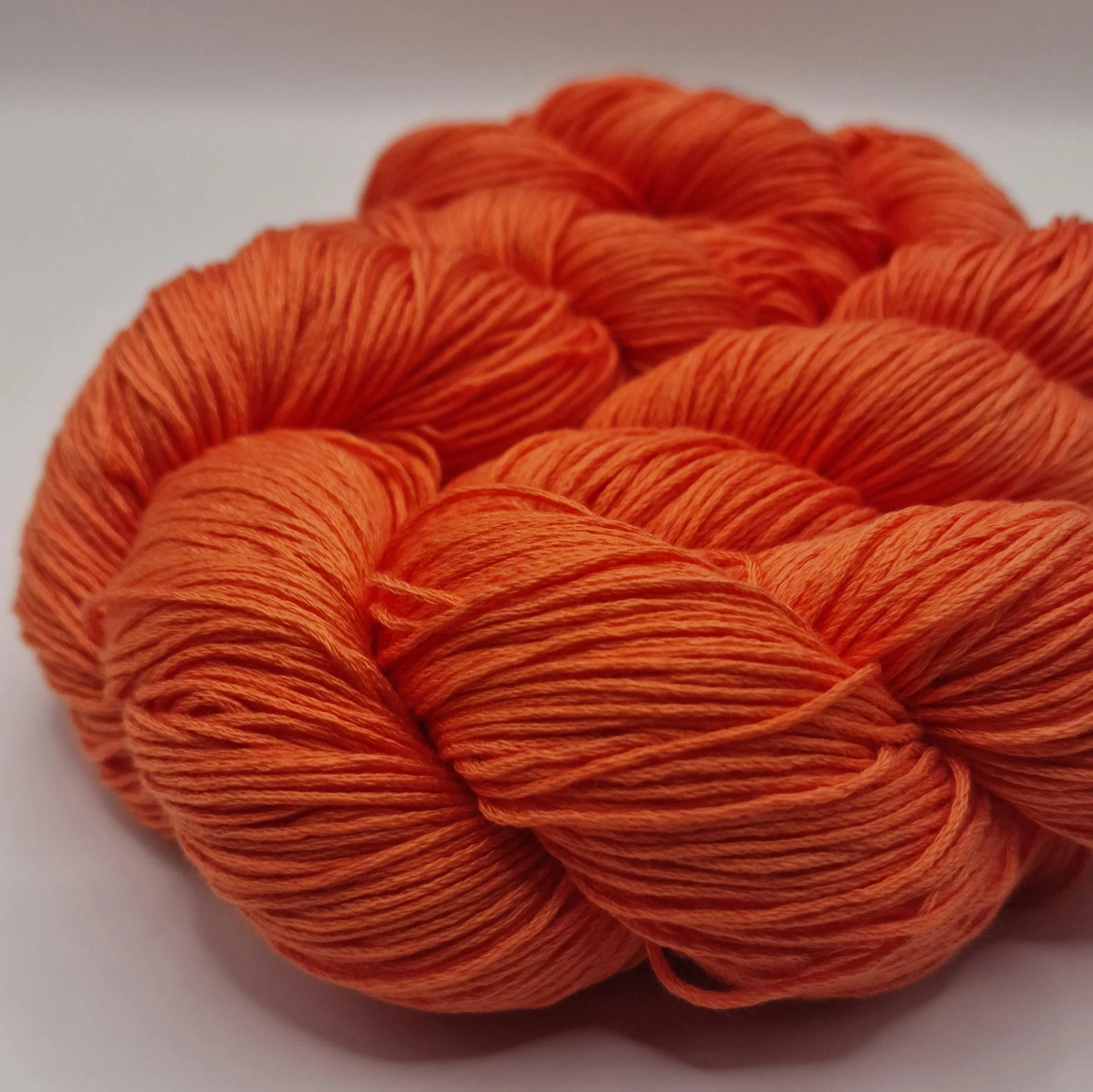 Lyocell Garn zwei Stränge in leuchtendem Orange auf weißem Untergrund