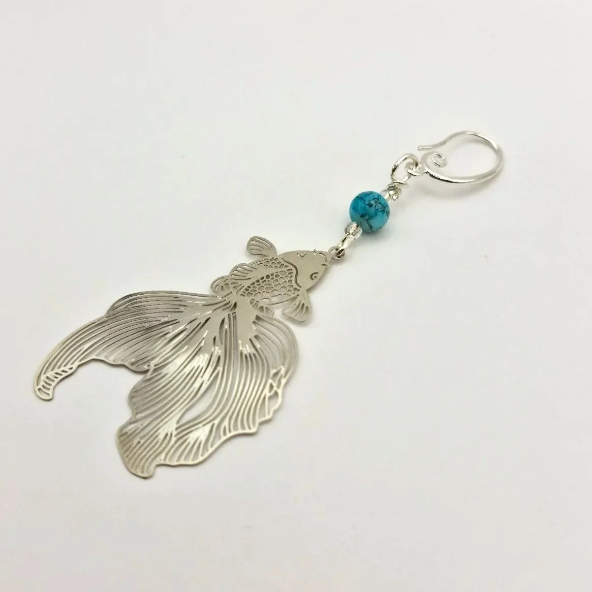 Progresskeeper Kampfschleierfisch in Silber mit blauer handbemalter Keramikperle und silbernem Anhänger auf weißem Untergrund