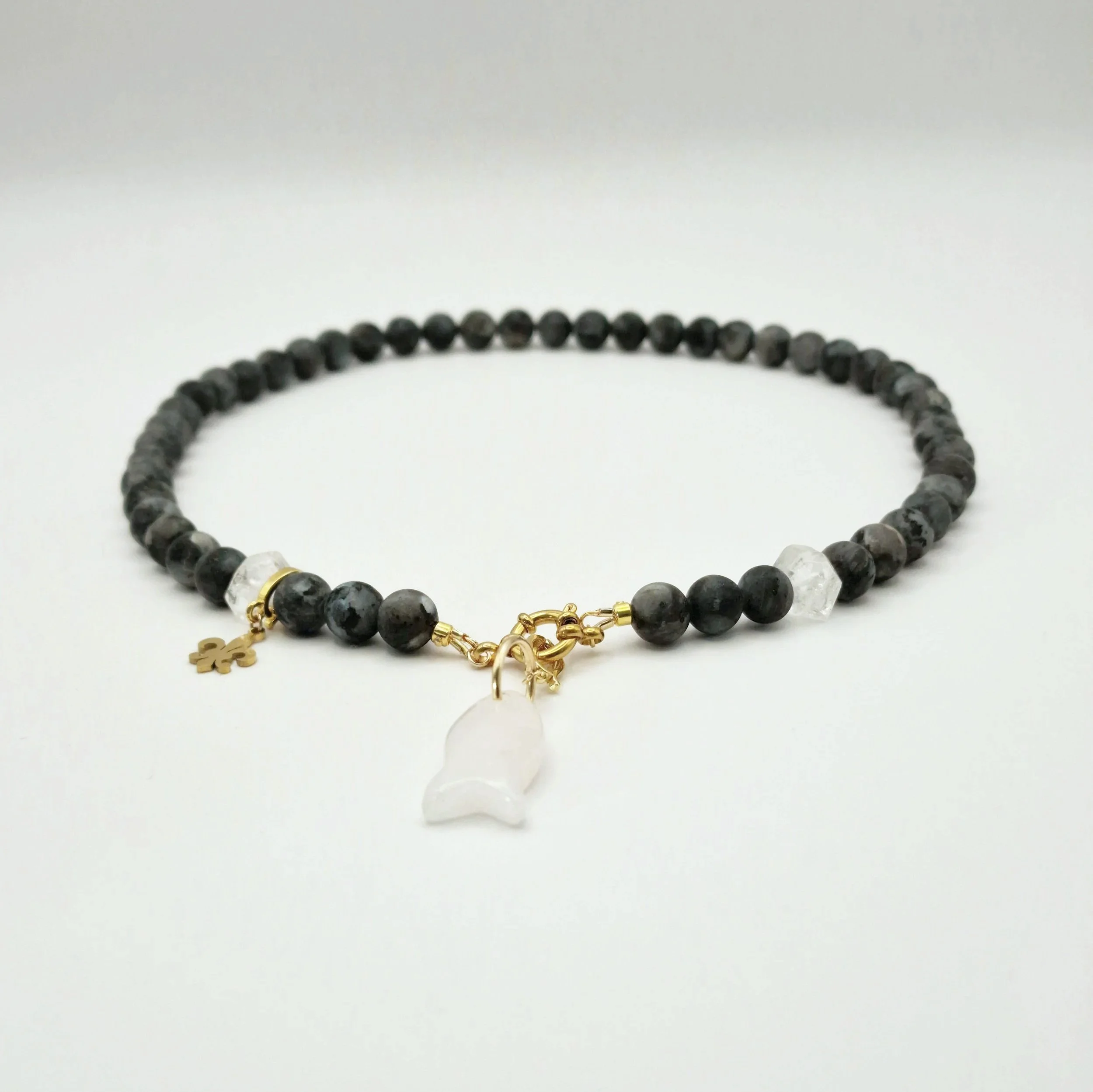 Kette aus Spektrolit, Bergkristall und Rosenquarzanhänger in Fischform mit vergoldetem Verschluss auf hellem Untergrund