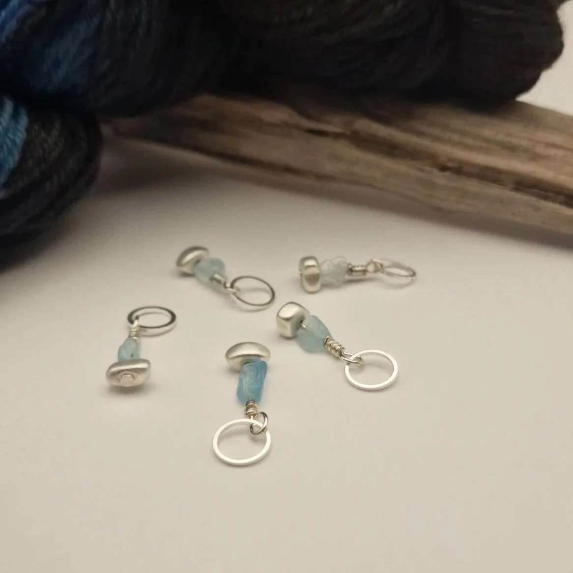 Set von 5 Maschenmarkierern mit Nuggets von Aquamarin und versilbertem matten Hämatit und versilberten Ringen auf weißem Untergrund