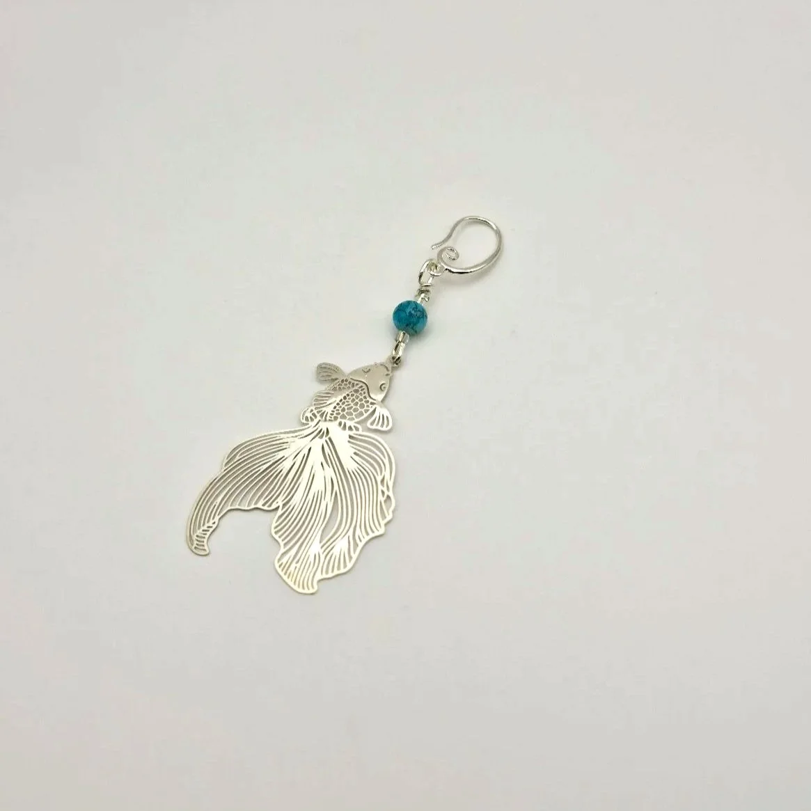 Progresskeeper Kampfschleierfisch in Silber mit blauer handbemalter Keramikperle und silbernem Anhänger auf weißem Untergrund