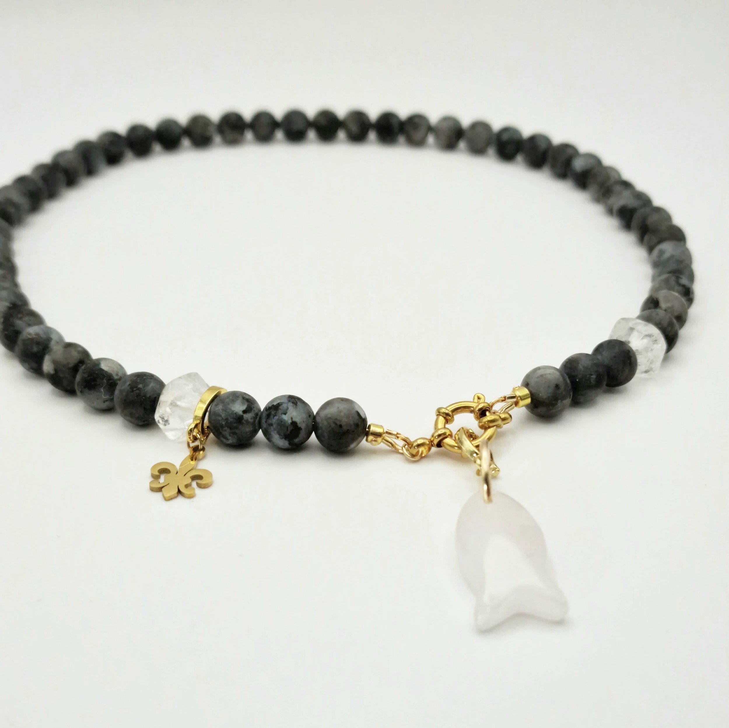 Kette aus Spektrolit, Bergkristall und Rosenquarzanhänger in Fischform mit vergoldetem Verschluss auf hellem Untergrund