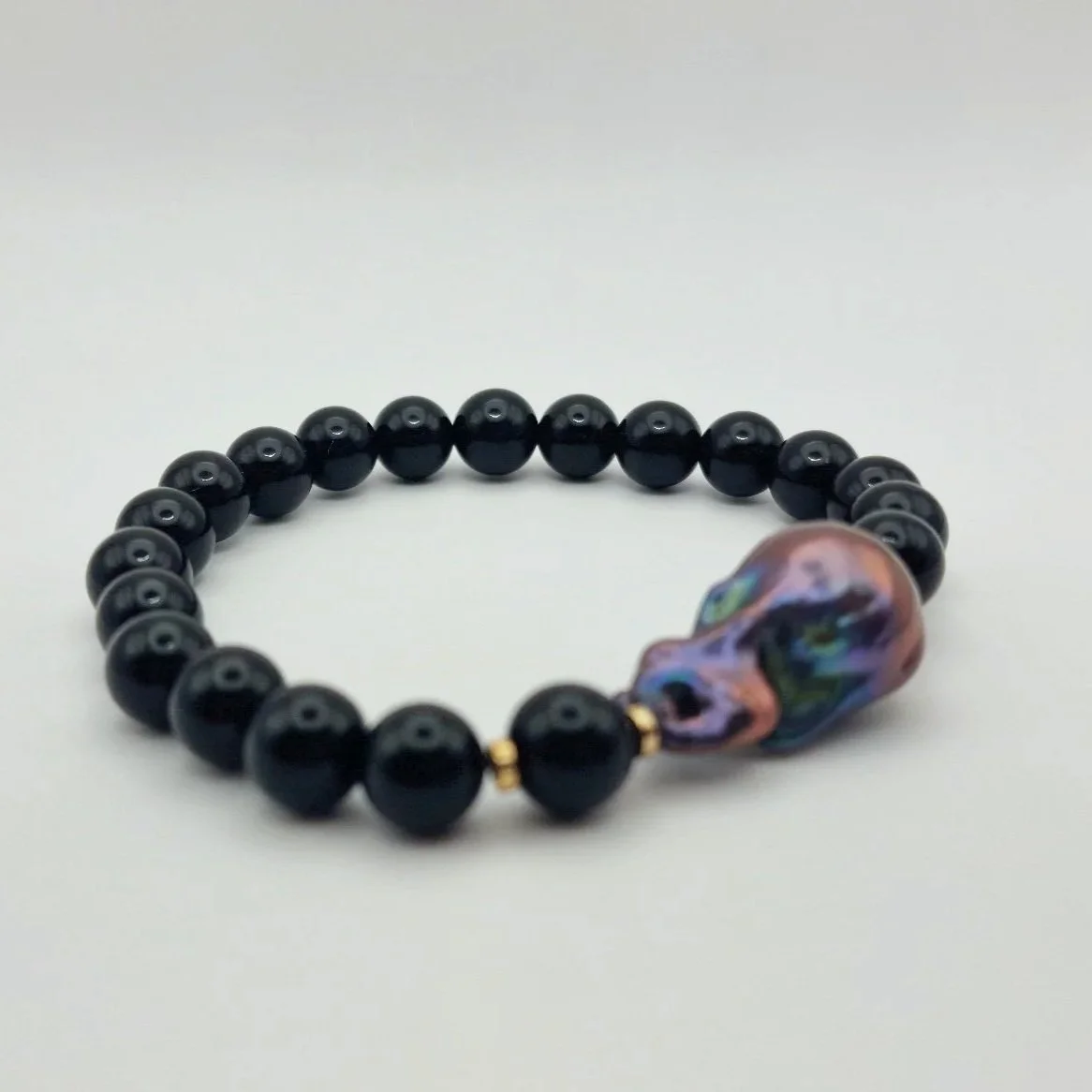 Armband aus tiefschwarzen Onyxperlen und einer violett schimmernden barocken Tahiti - Perle