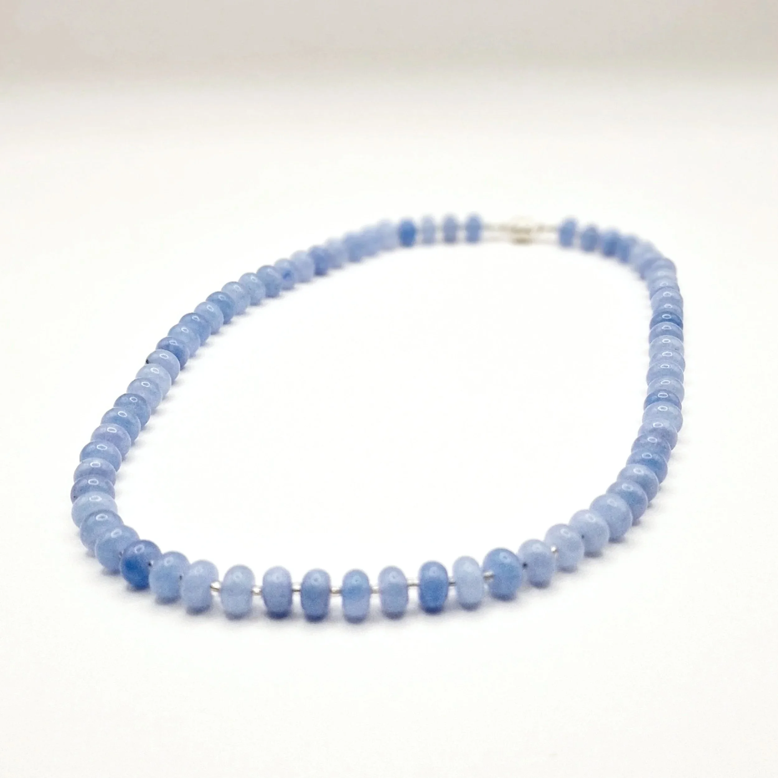 Kette aus blauen Aquamarinperlen und silbernem Magnetverschluss auf hellem Untergrund