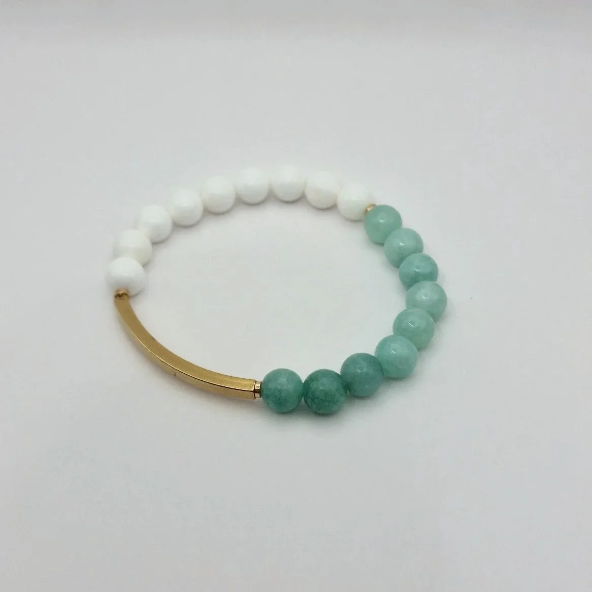 Exklusives Unikat-Armband Hebe mit einem rhythmischen Wechselspiel aus weißen Korallenperlen und mintgrüner burmesischer Jade.