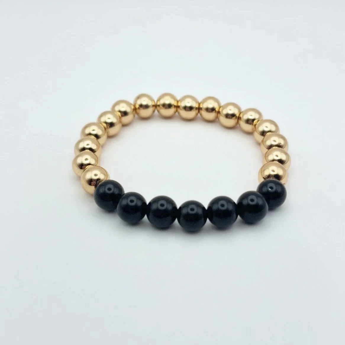 Armband Hekate aus vergoldetem Hämatit und schwarzem glänzenden Onyx auf weißem Untergrund