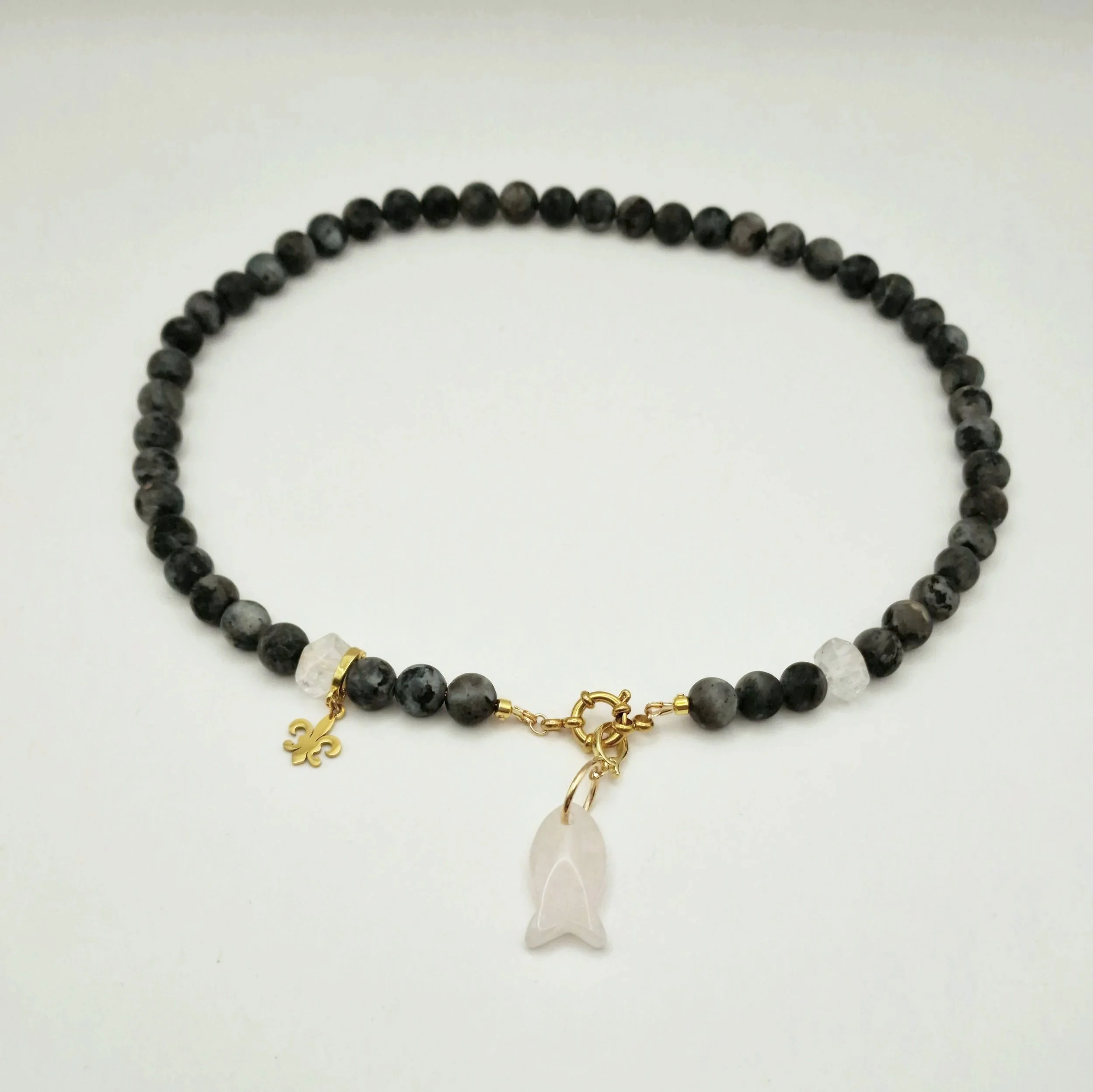 Kette aus Spektrolit, Bergkristall und Rosenquarzanhänger in Fischform mit vergoldetem Verschluss auf hellem Untergrund