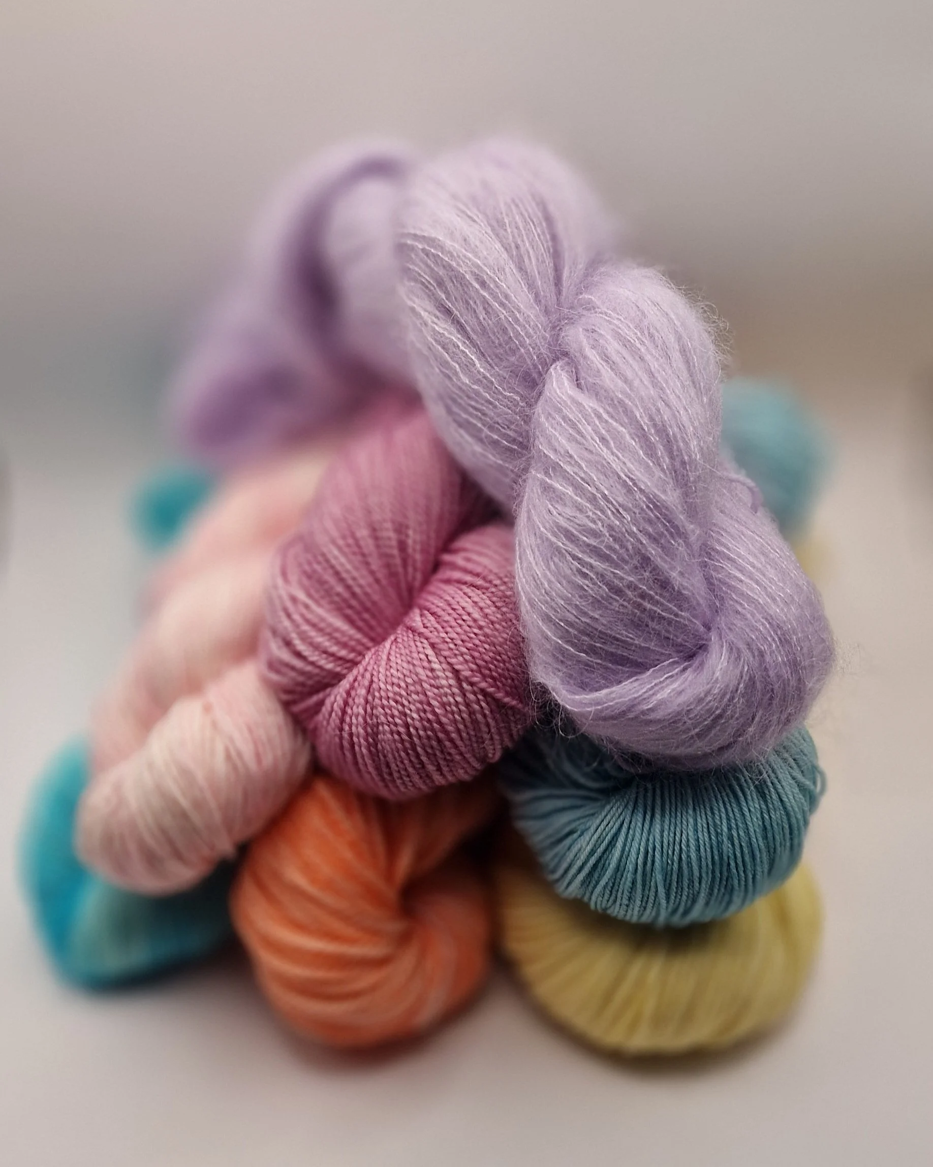 verschiedenfarbige Stränge handgefärbte Wolle auf hellem Untergrund