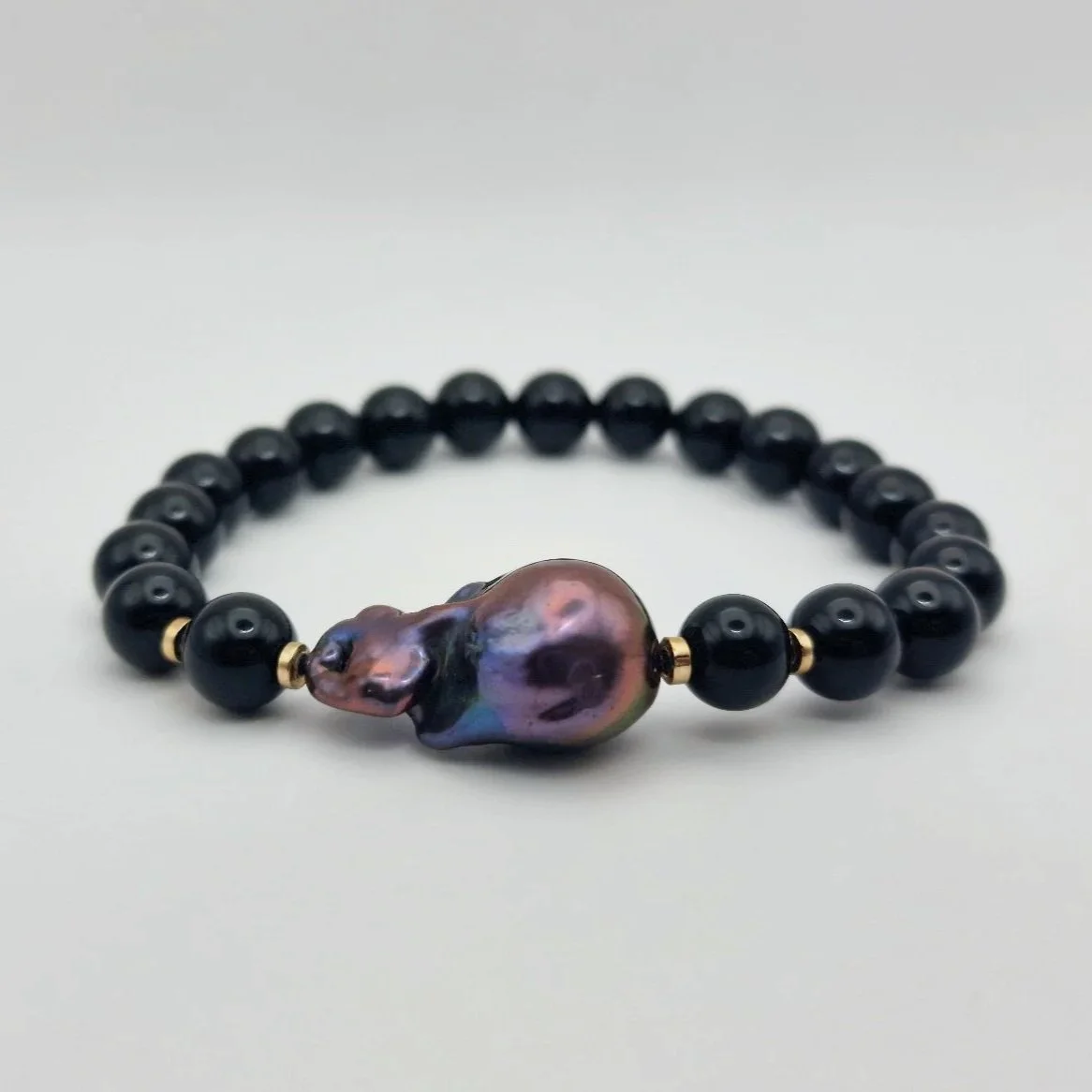 Armband aus tiefschwarzen Onyxperlen und einer violett schimmernden barocken Tahiti - Perle