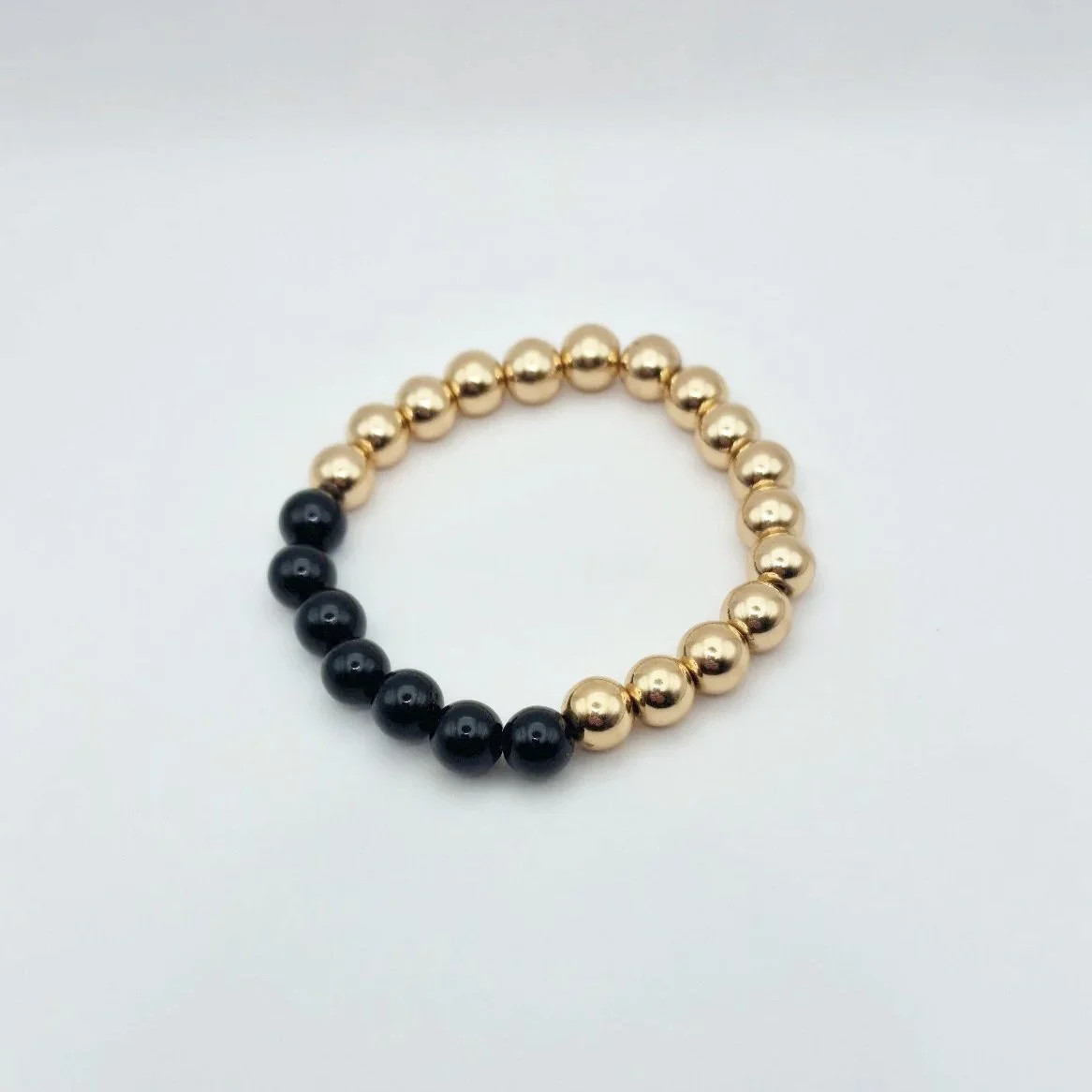 Armband Hekate aus vergoldetem Hämatit und schwarzem glänzenden Onyx auf weißem Untergrund