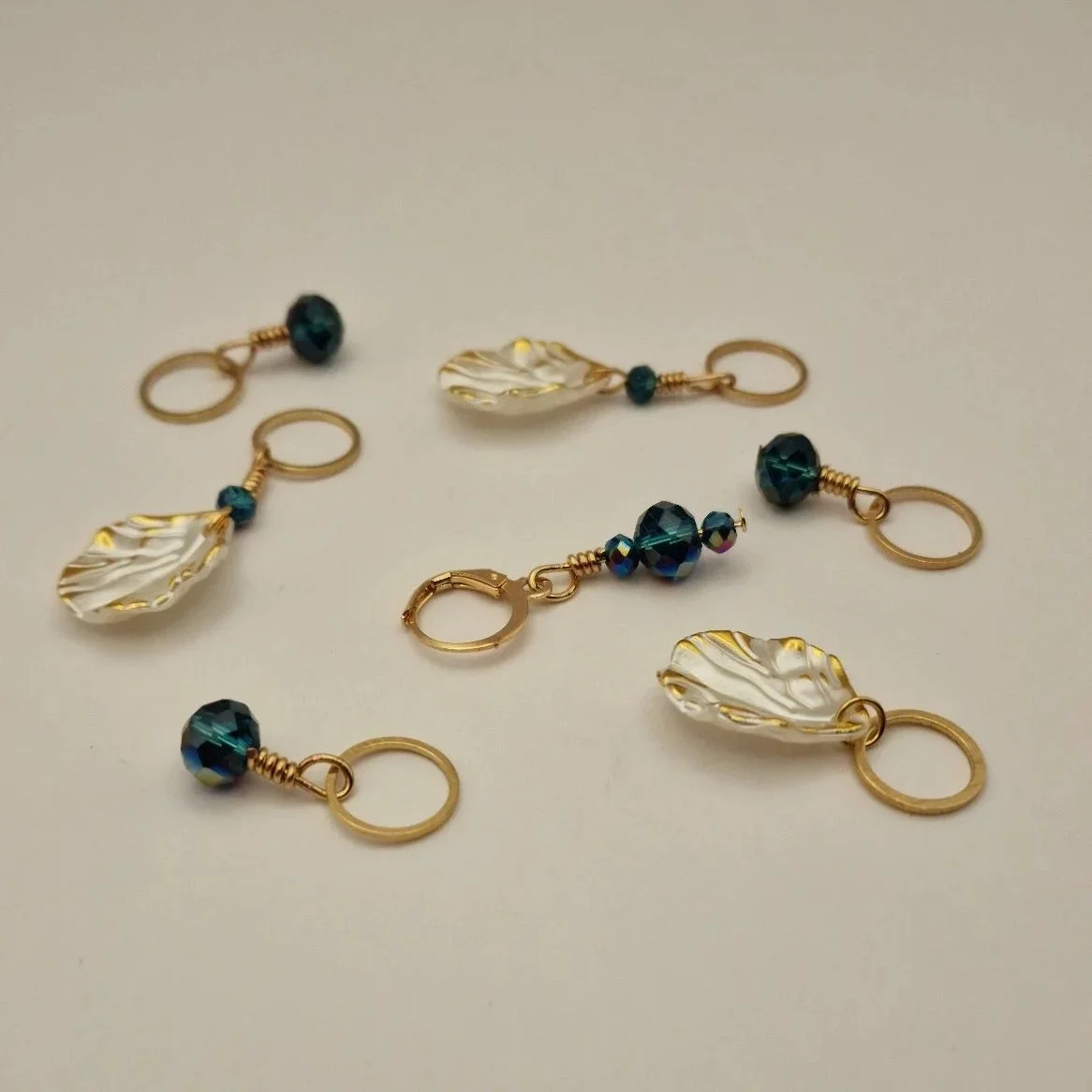 Set aus 6 Maschenmarkierern und einem Progresskeeper in weiß gold und blau auf hellem Untergrund