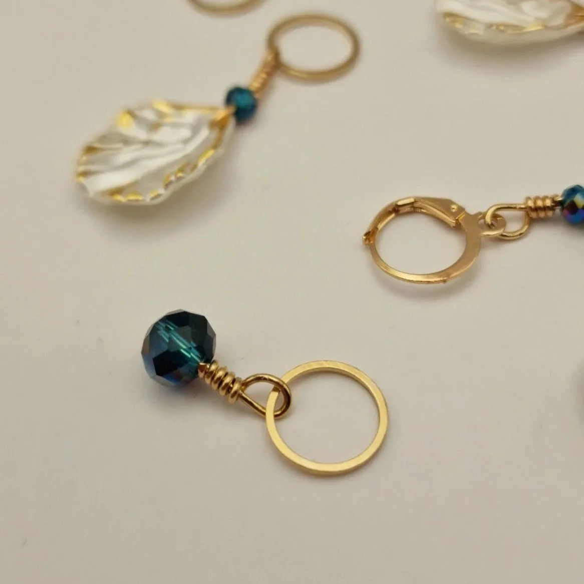 Set aus 6 Maschenmarkierern und einem Progresskeeper in weiß gold und blau auf hellem Untergrund