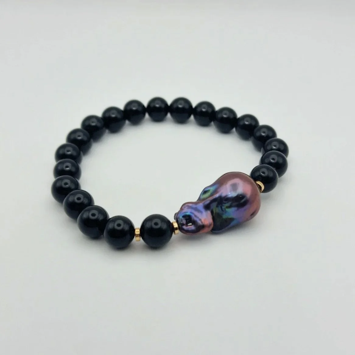 Armband aus tiefschwarzen Onyxperlen und einer violett schimmernden barocken Tahiti - Perle