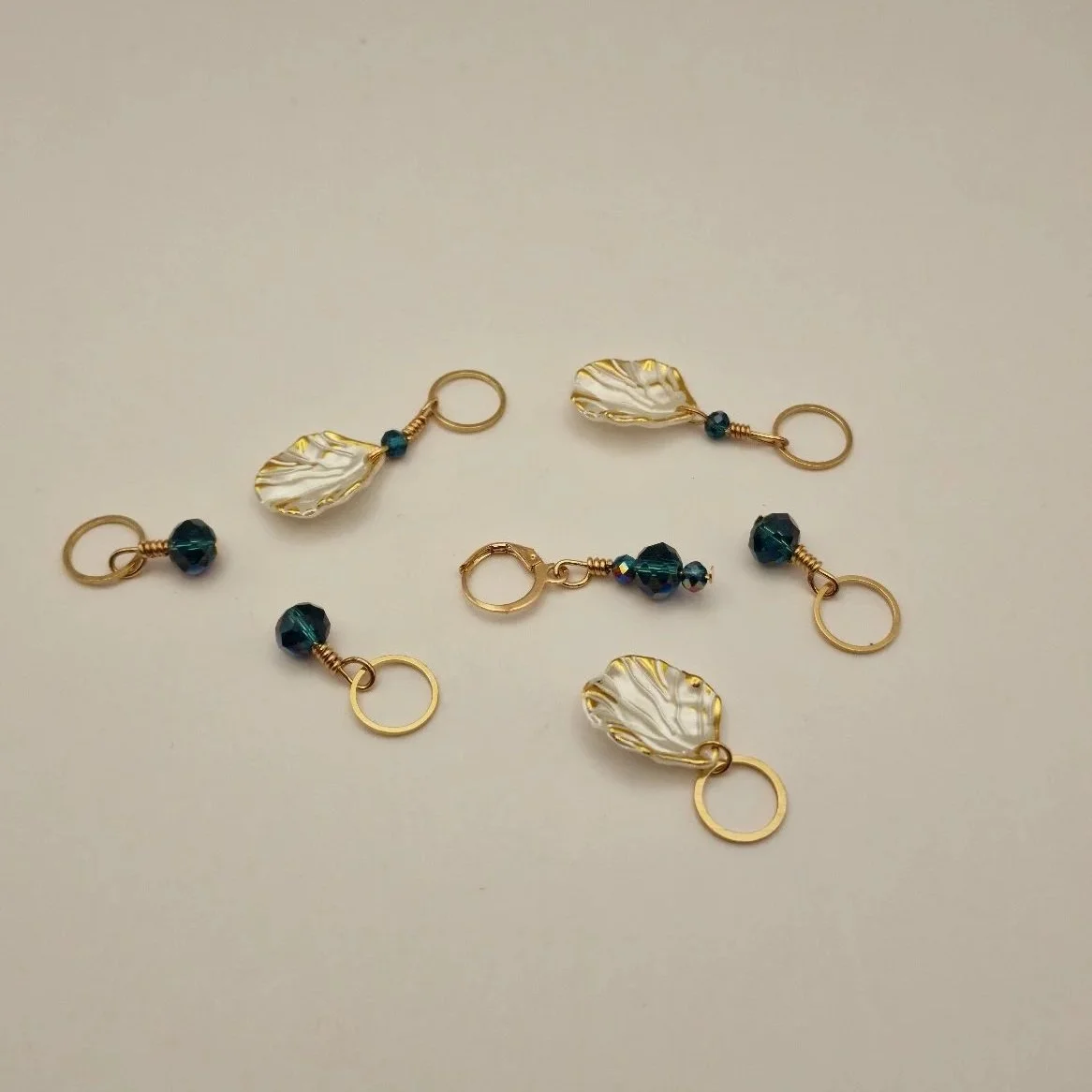 Set aus 6 Maschenmarkierern und einem Progresskeeper in weiß gold und blau auf hellem Untergrund