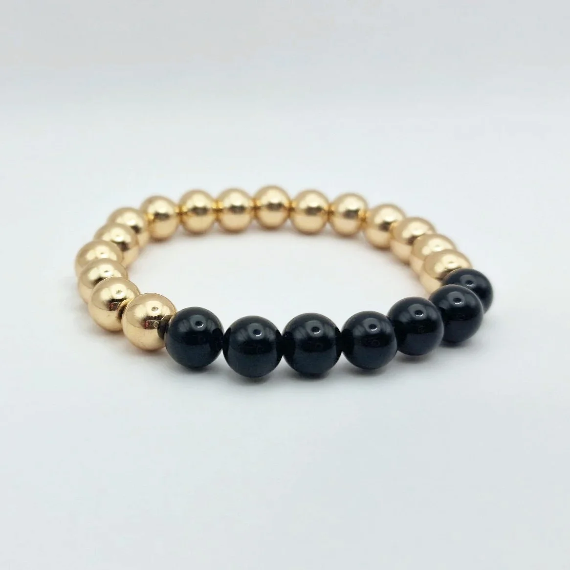 Armband Hekate aus vergoldetem Hämatit und schwarzem glänzenden Onyx auf weißem Untergrund
