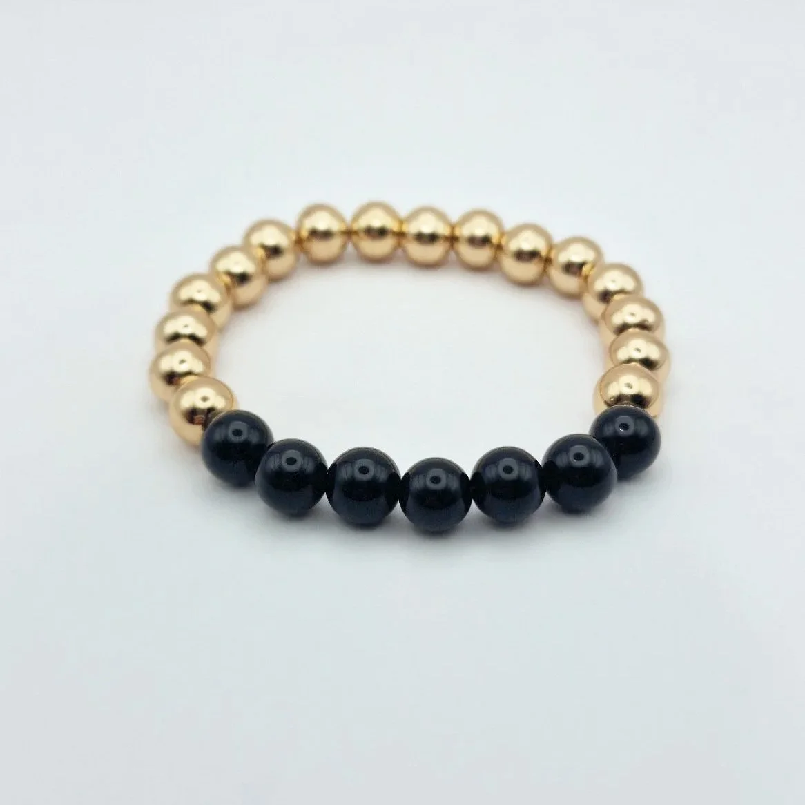 Armband Hekate aus vergoldetem Hämatit und schwarzem glänzenden Onyx auf weißem Untergrund