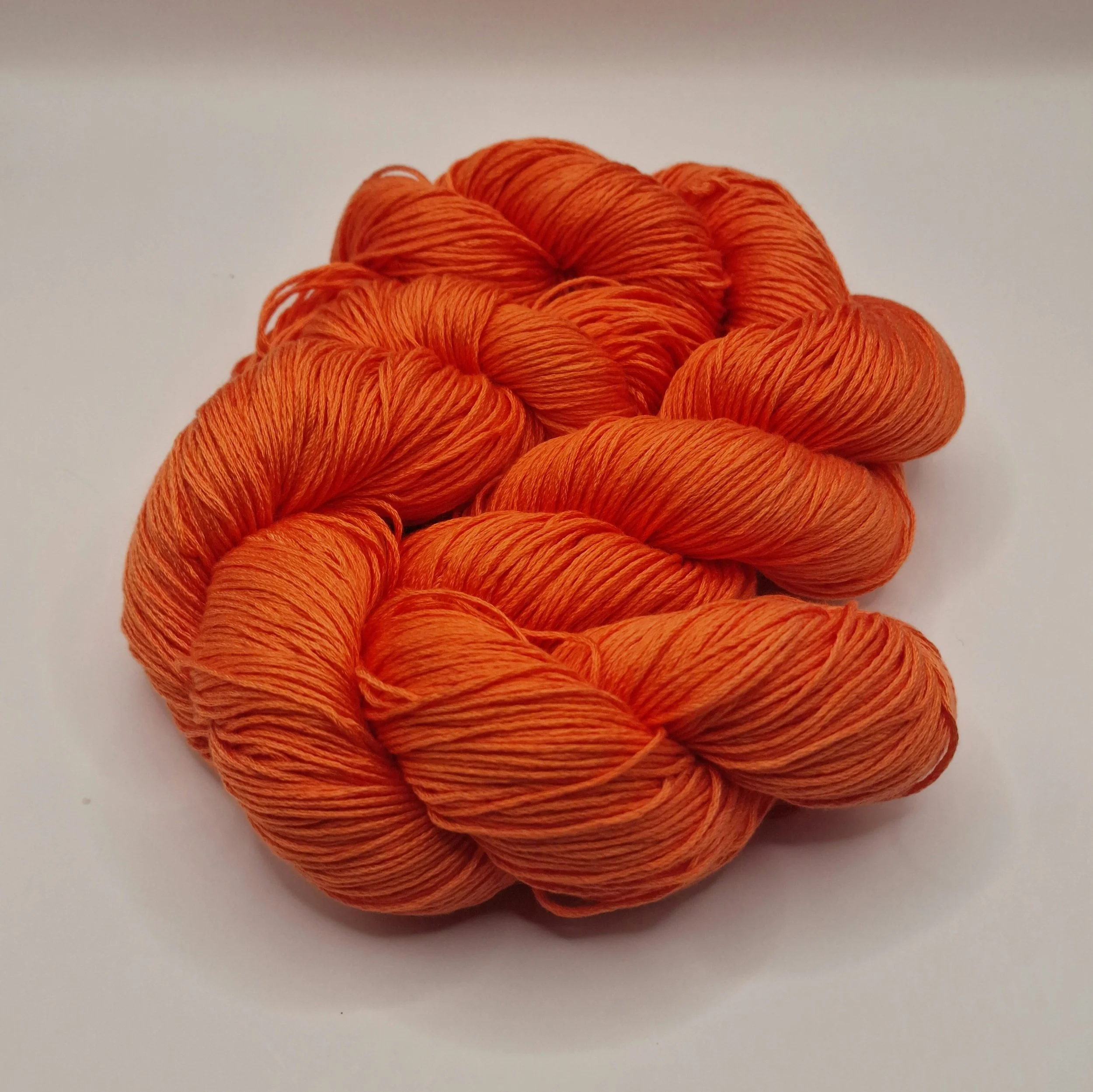 Lyocell Garn zwei Stränge in leuchtendem Orange auf weißem Untergrund