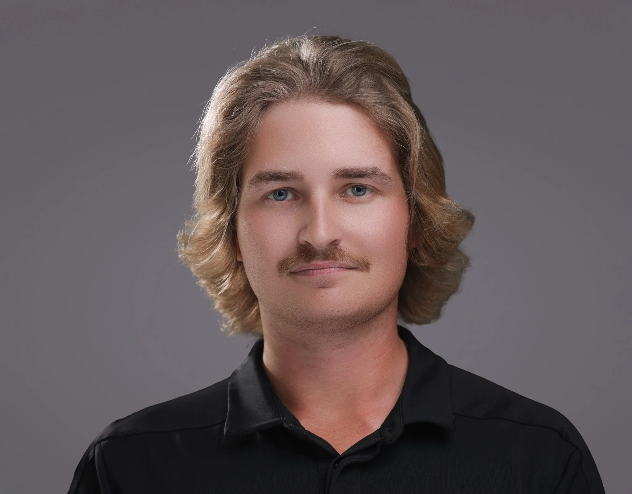 Portrait of a young man with shoulder-length blond hair, blue eyes, and a light mustache, wearing a black collared shirt against a gray background.