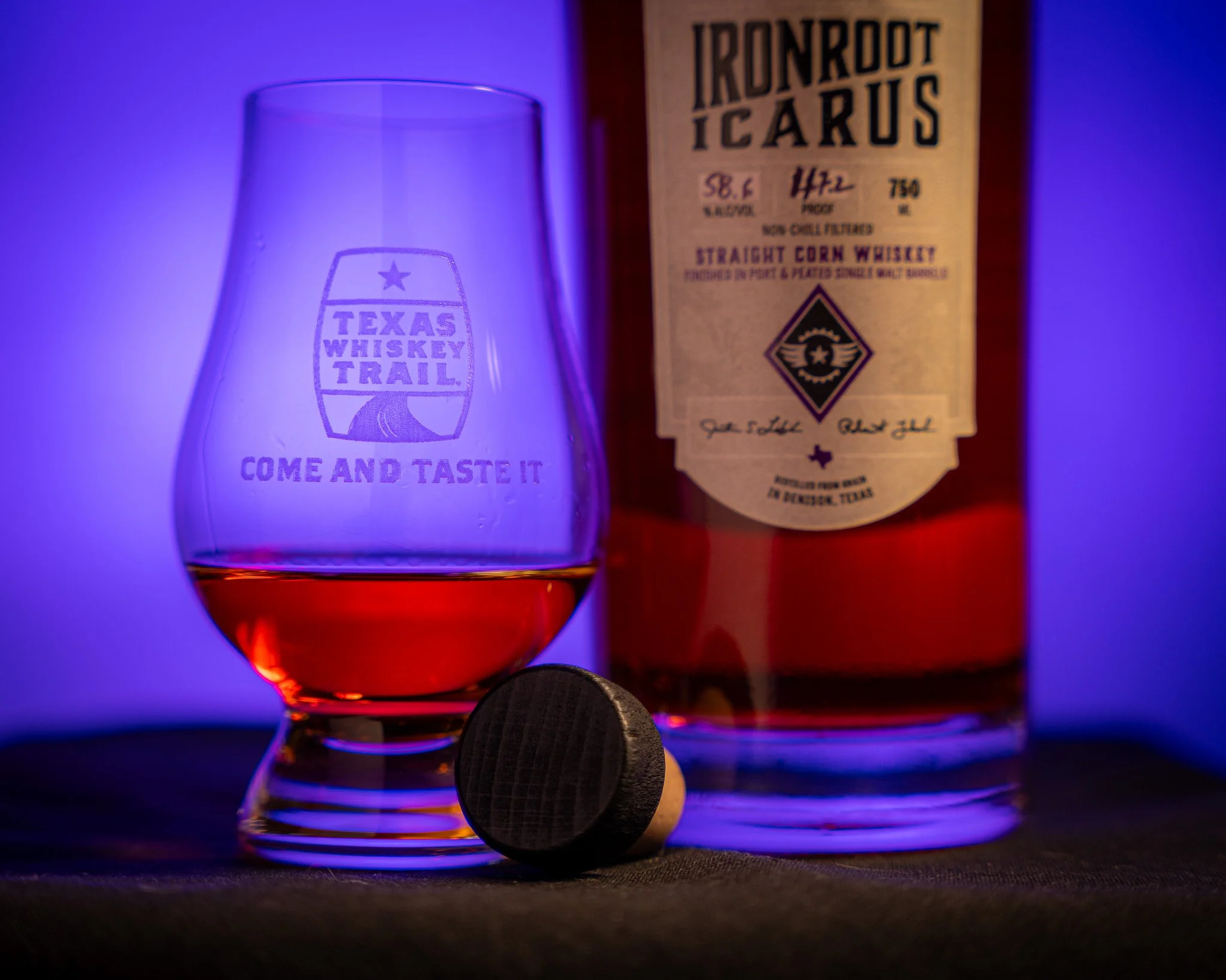 A glass of Ironroot Icarus next to the bottle