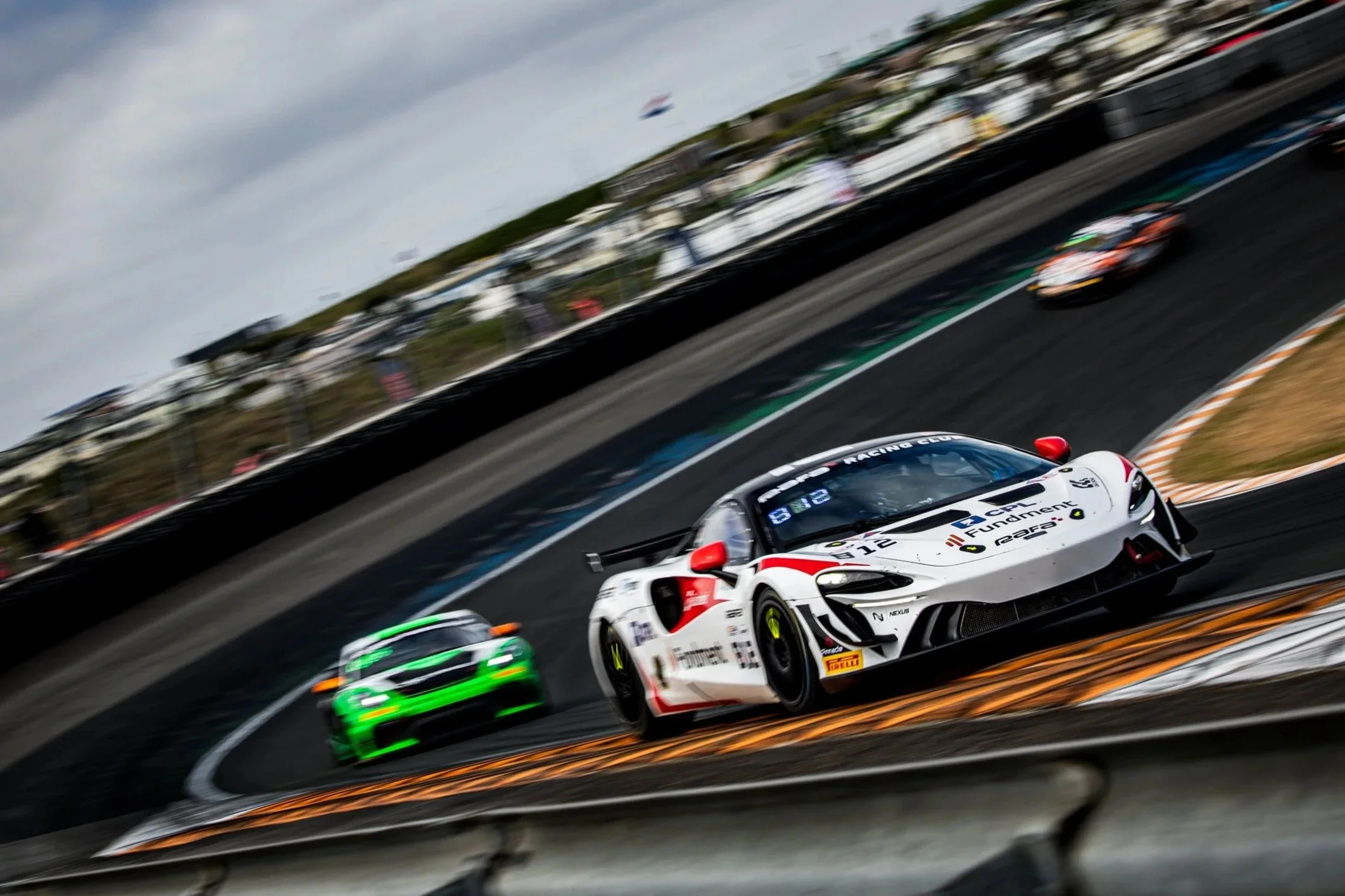 Charlie Hart's #812 McLaren Artura GT4 on track at Zandvoort Circuit, as the car takes the famous banked corner.