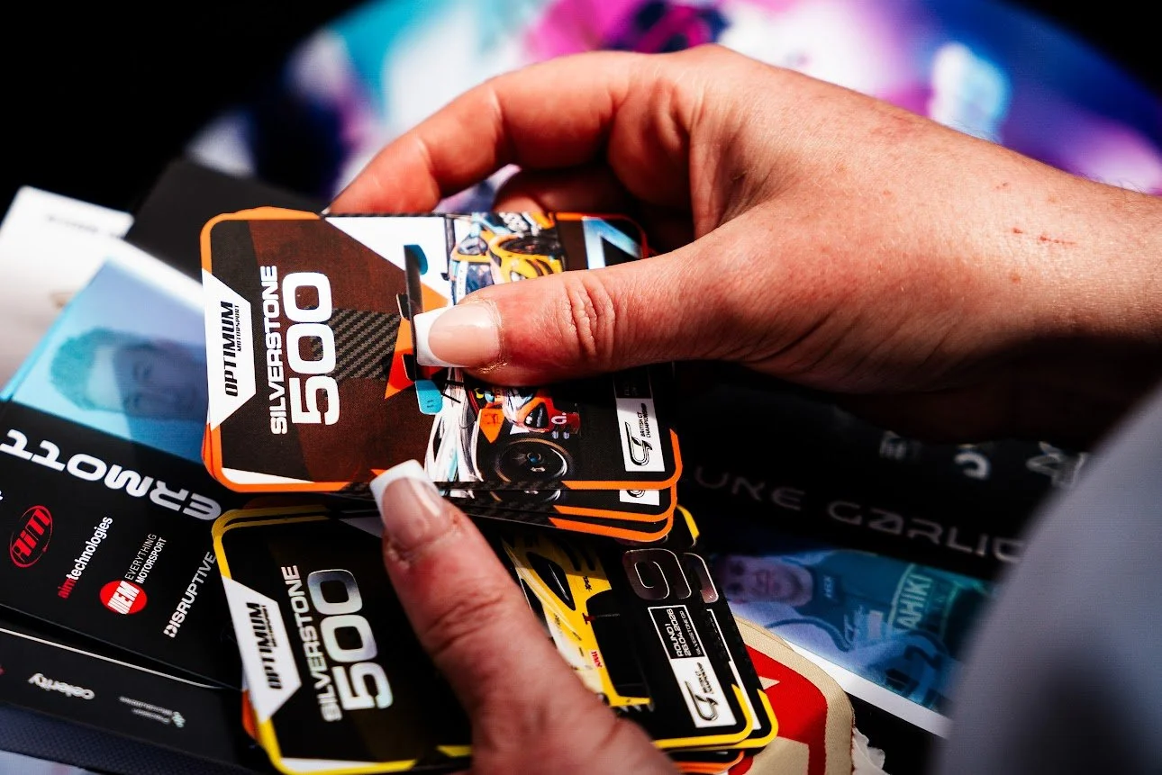 A selection of limited edition trading cards designed for Optimum Motorsport collected by a fan during British GT event at Silverstone. the cards showcase images of the cars, and driver autographs, with a silver foiled holographic element which shine
