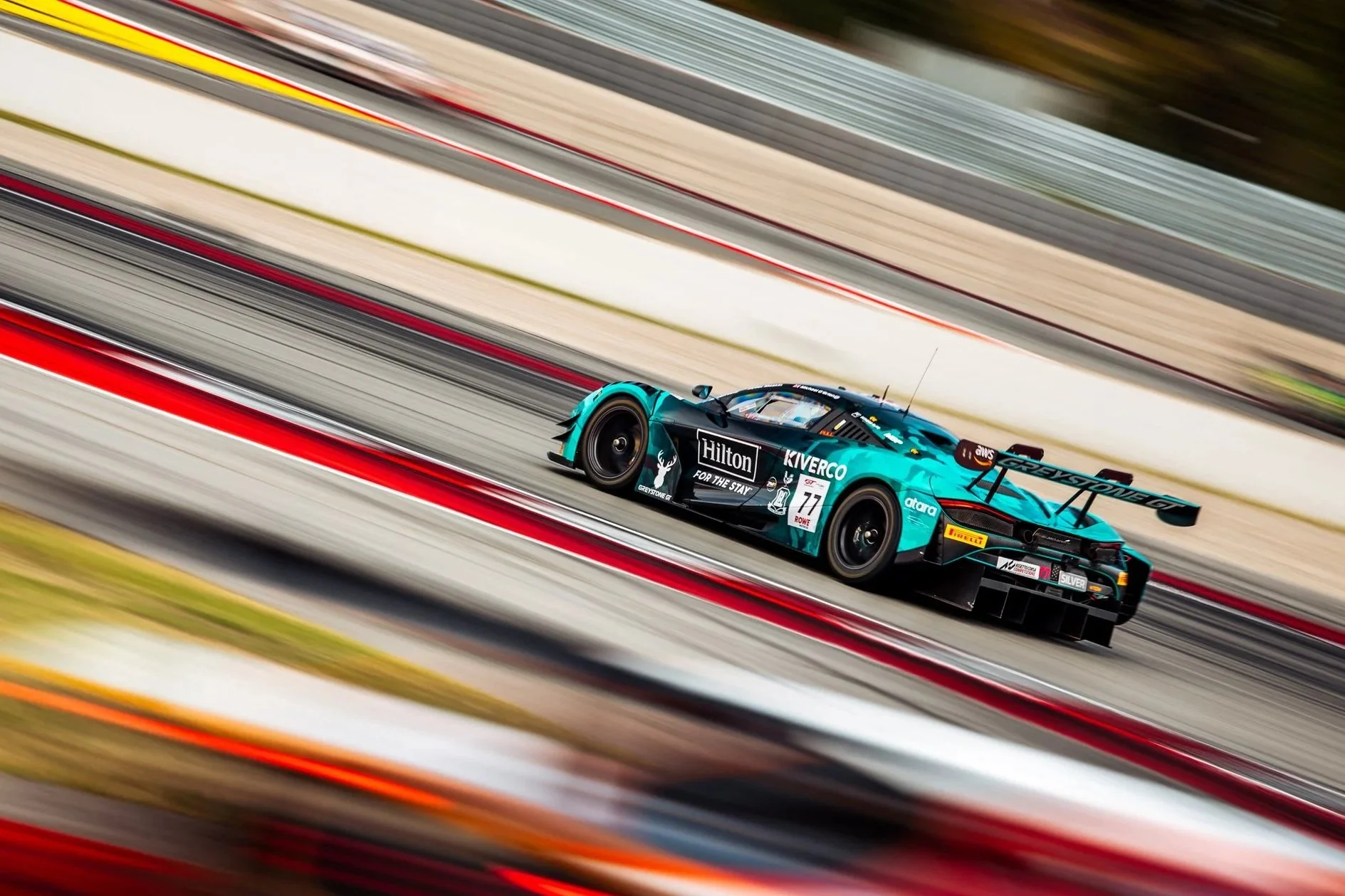 Zac Meakin's McLaren 720S GT3 on track at Barcelona Circuit featuring motion blur.
