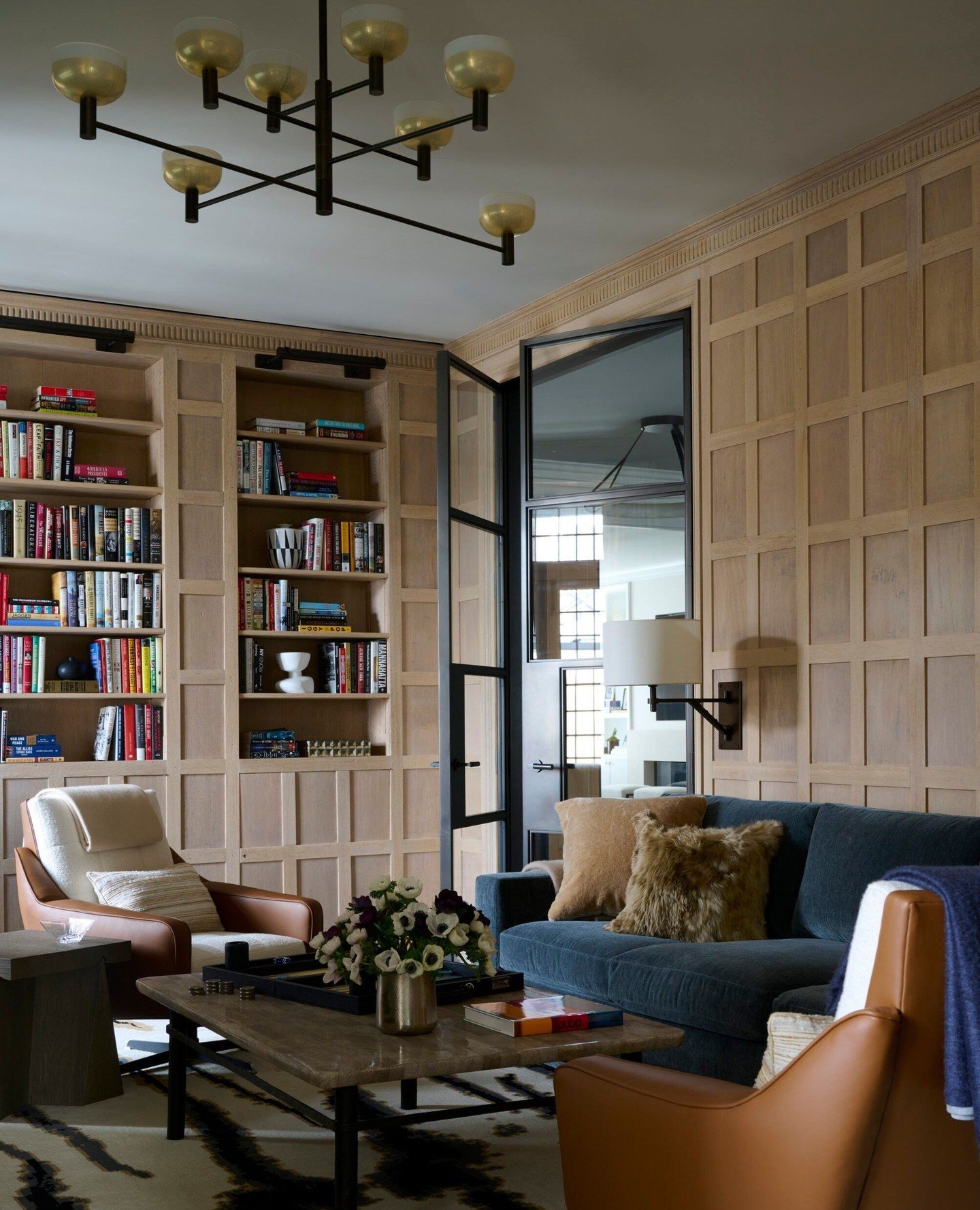 This cozy room by @victoriahaganinteriors has it all - wood panelled walls, a statement light fixture, and lots of texture! Casual luxury at its finest.⁠
⁠
Photo by @williamwaldronphoto