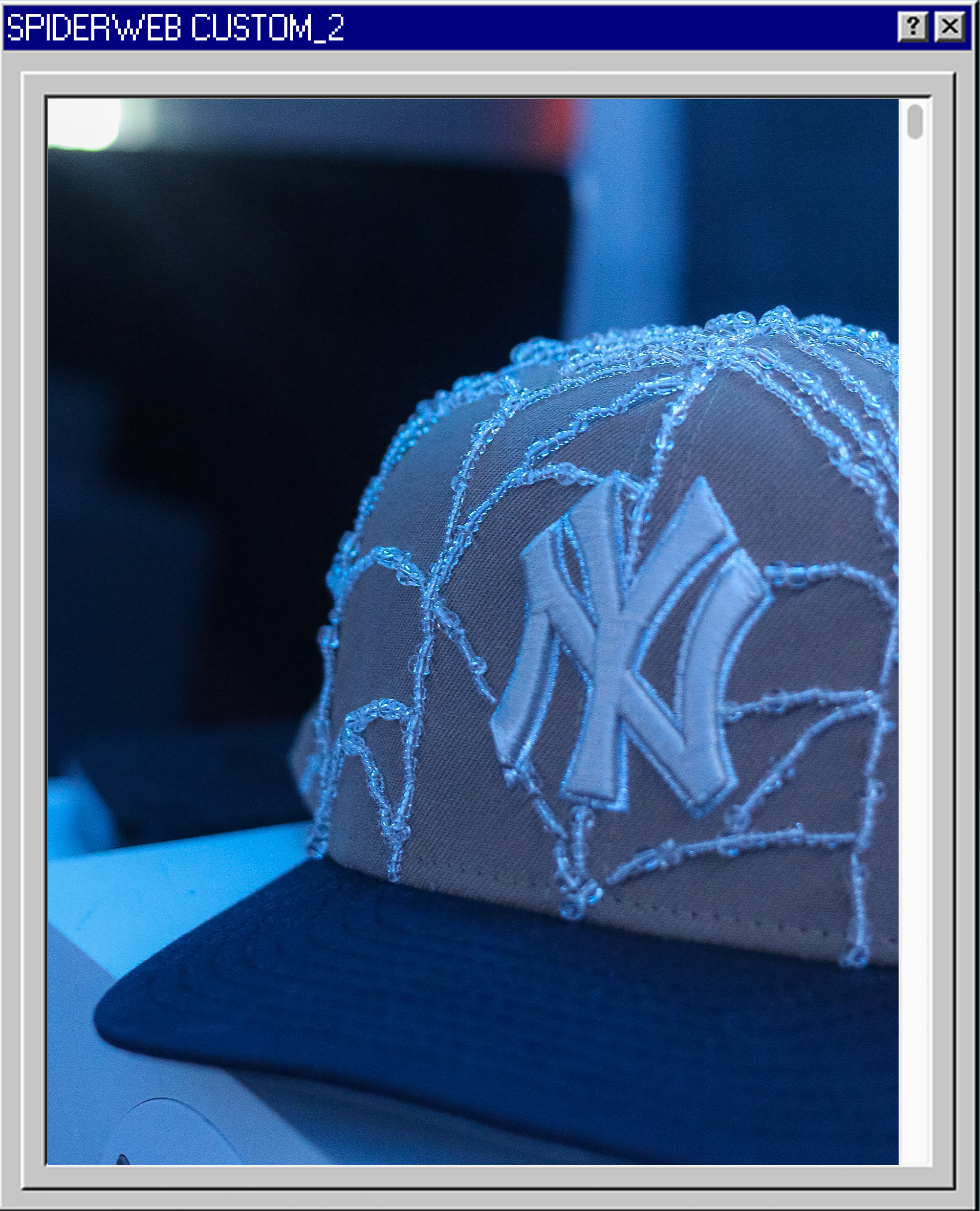 A beige New York Yankees snapback hat with embroidery of the Yankees logo and decorative stitching, sitting on a surface with a blurred background.