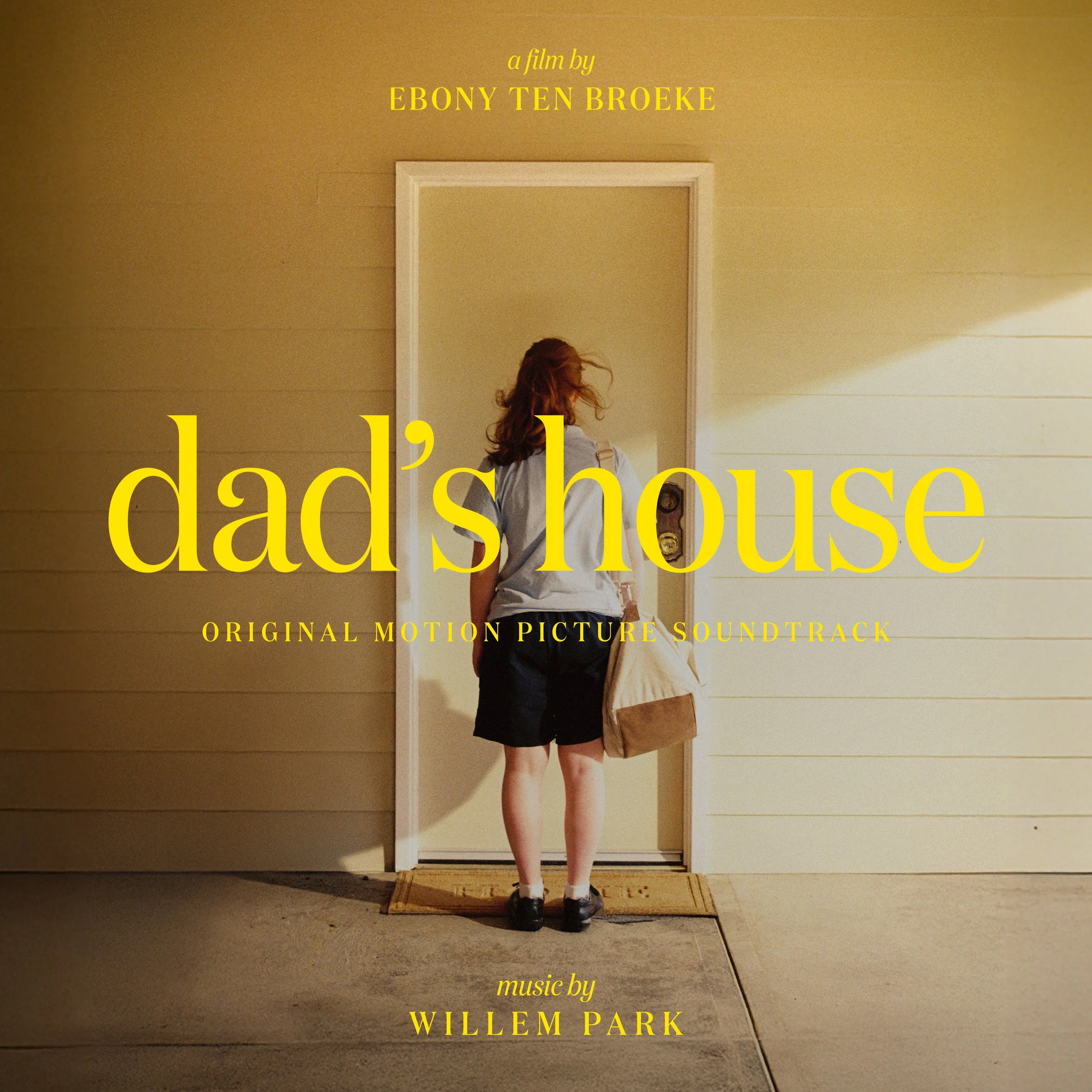 A person with red hair standing in front of a white door on a yellow house wall, carrying a bag, with text overlay for a movie soundtrack.