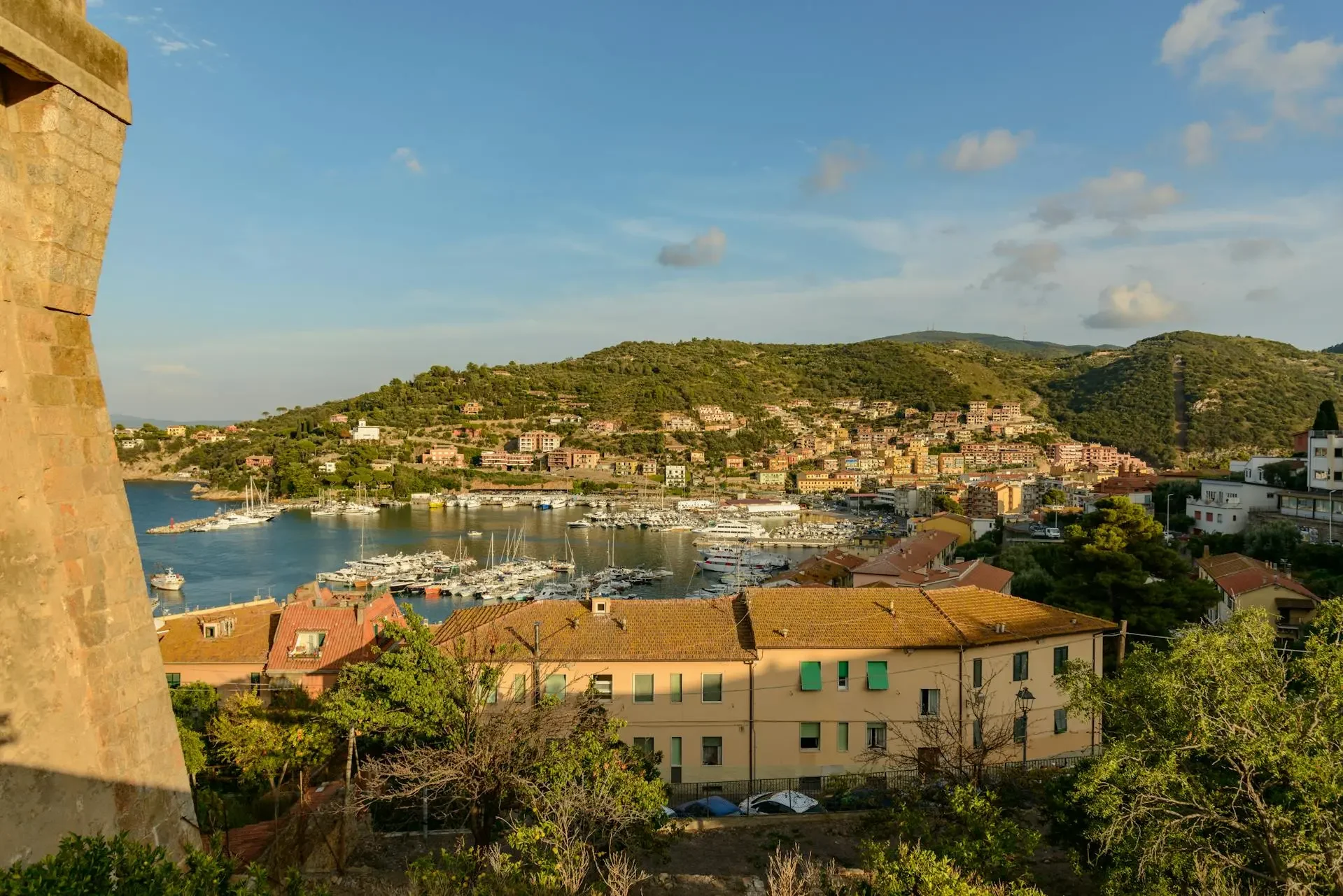 Stunning capture of Porto Ercole with a beautiful harbor and lush hills in the background..