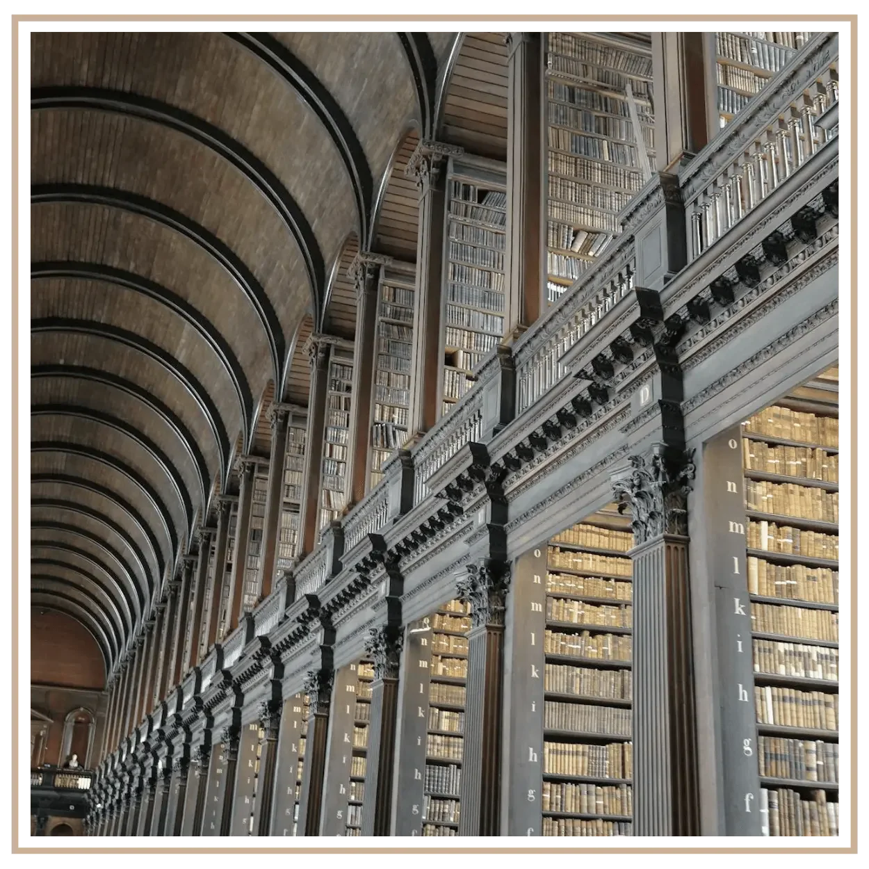 An editorial style photograph of the massive Trinity College library in Dublin, Ireland.