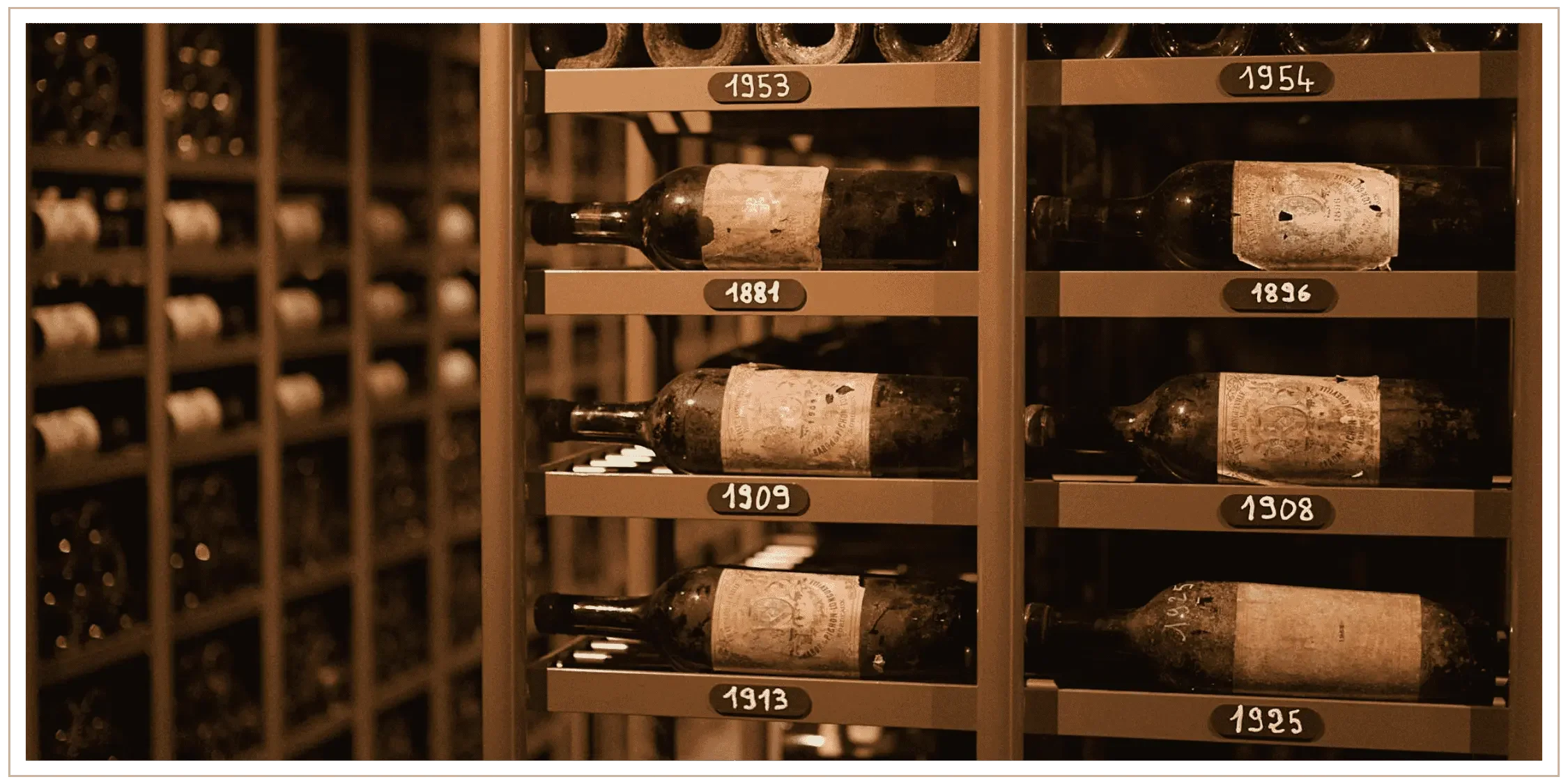 Dusty wine bottles with signs of the vintages from 1881 to 1954 in a private wine cellar in France, representing the authentic curation and vetted experiences coordinated by travel advisor Denise Kubica.