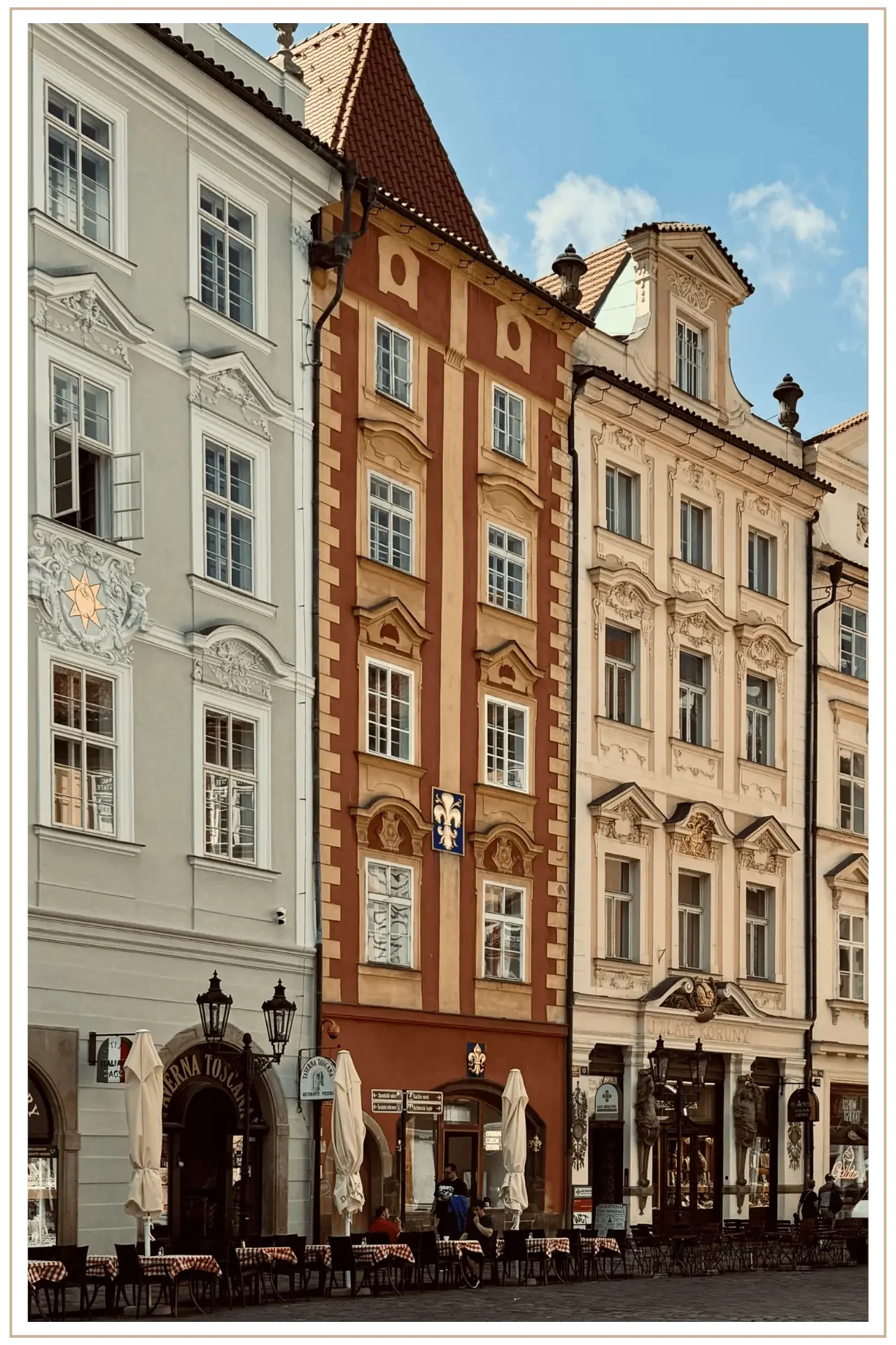 Street-level view of historic European architecture with colorful facades, cobblestone streets, and outdoor cafe seating in a central pedestrian district.