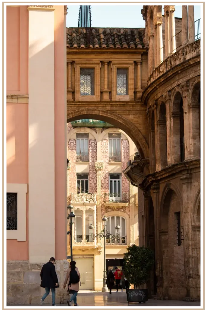 Archway connecting Valencia Cathedral to the Archbishop's Palace, framing the historic Casa del Punto de Gancho in Plaza de la Almoina, Valencia, Spain. Custom itinerary planning to Europe by Denise Kubica.