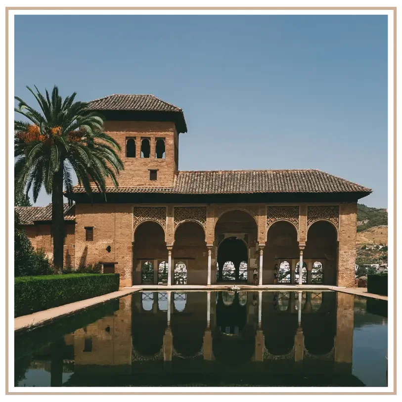 The Partal Palace (Palacio del Partal) and Tower of the Ladies reflecting in a serene pool at the Alhambra complex in Granada, Spain. Custom Spain luxury travel itinerary design for US travelers by US-based travel advisor Denise at Mindset Travel.
