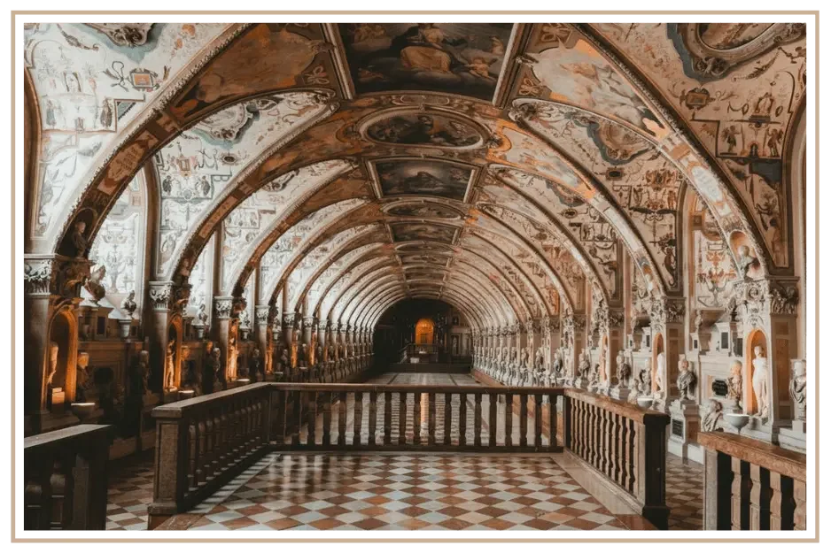 Quiet hall of the Munich Residenz Antiquarium filled with busts and frescoes.