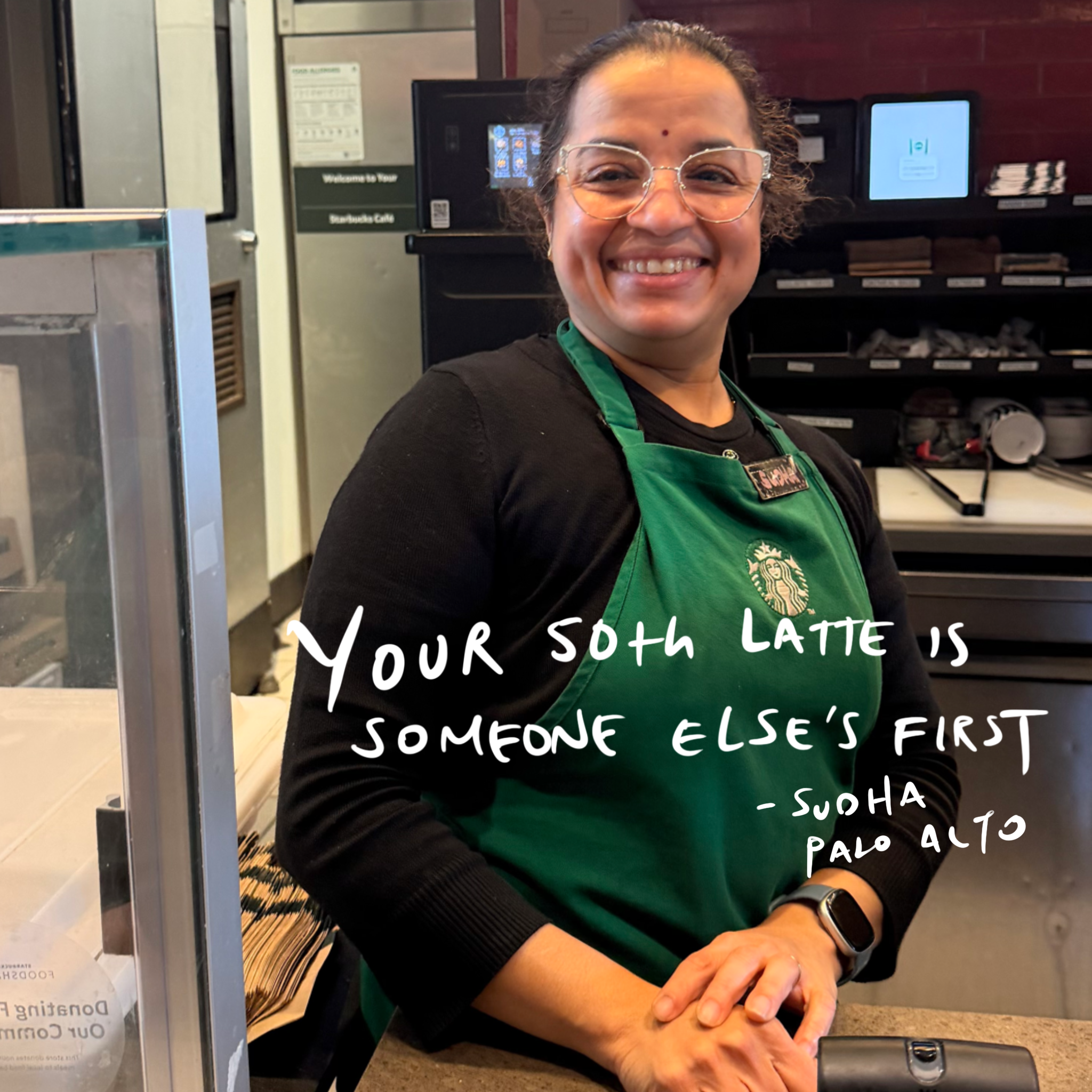 Sudha, a district trainer at the Stanford campus Starbucks, standing behind the espresso bar during a conversation with Brandon Ivan Peña about leadership and developing people.