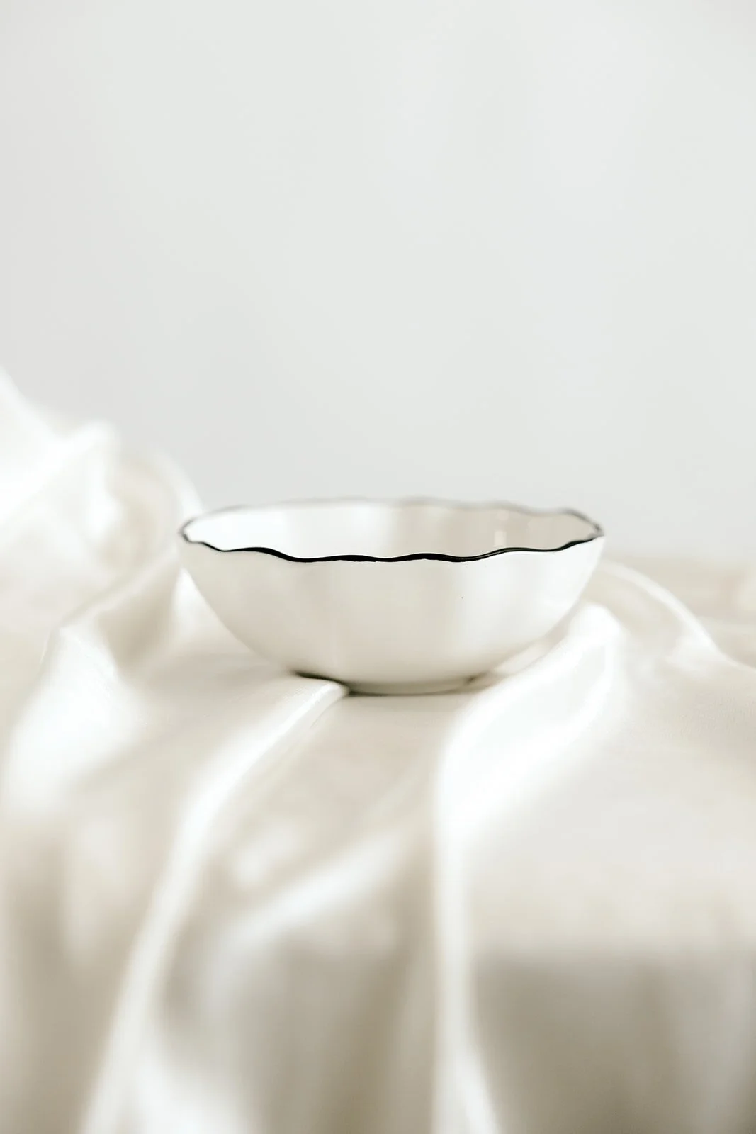white wavy bowl with black rim