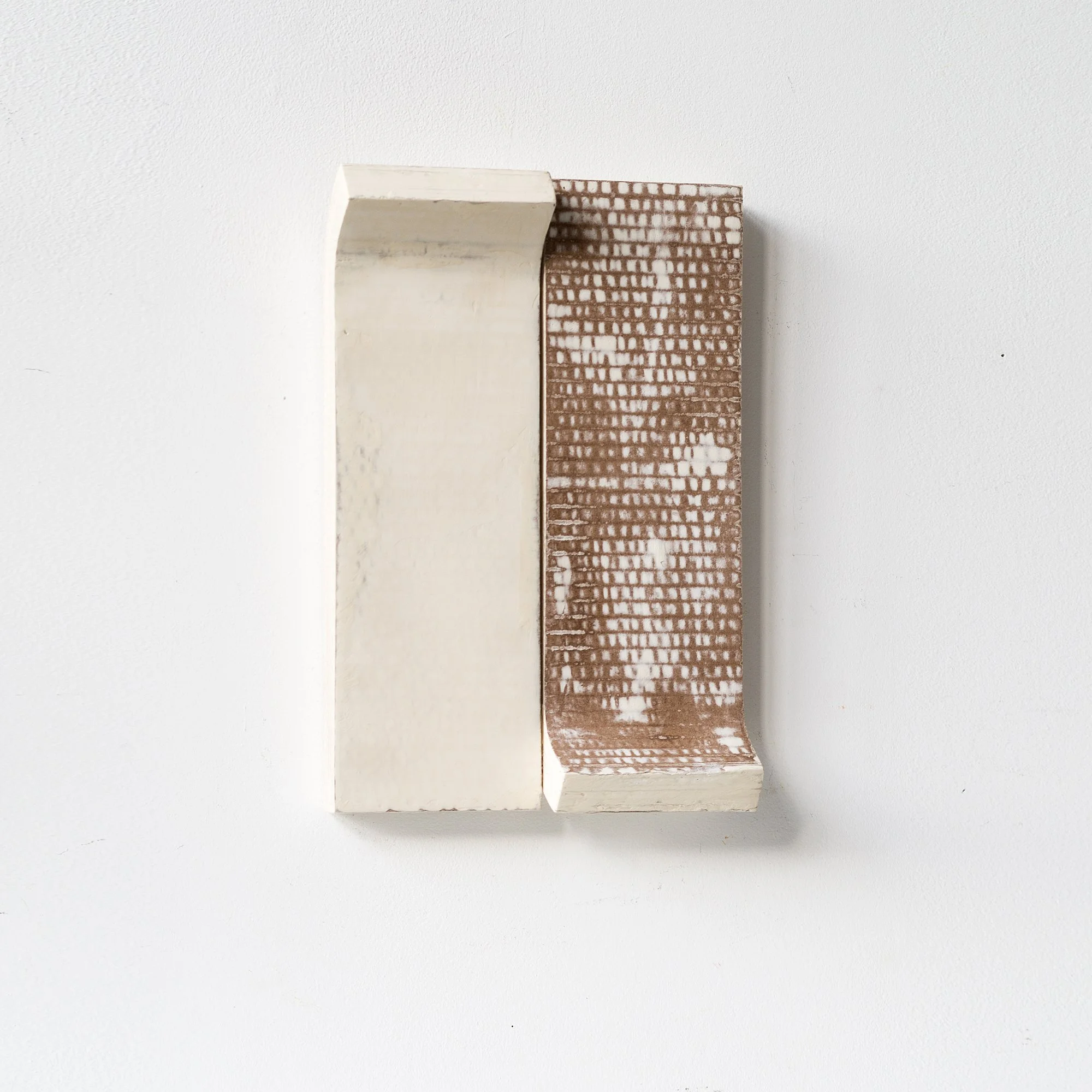 SOLD

Abstract sculpture with geometric shapes, textured white and brown surfaces, mounted on a wall.