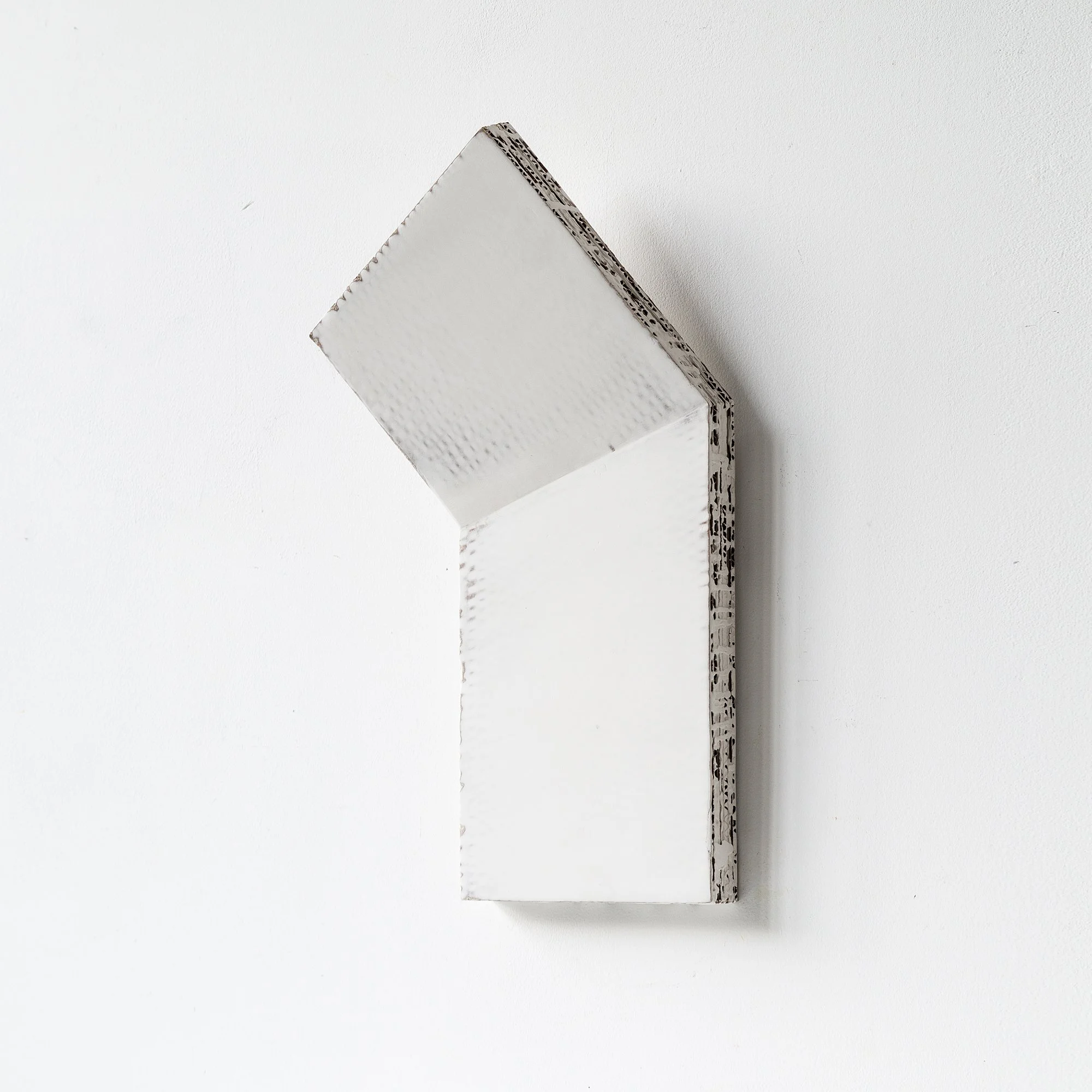 SOLD

A minimalist, geometric, wall-mounted sculpture with a white textured surface.
