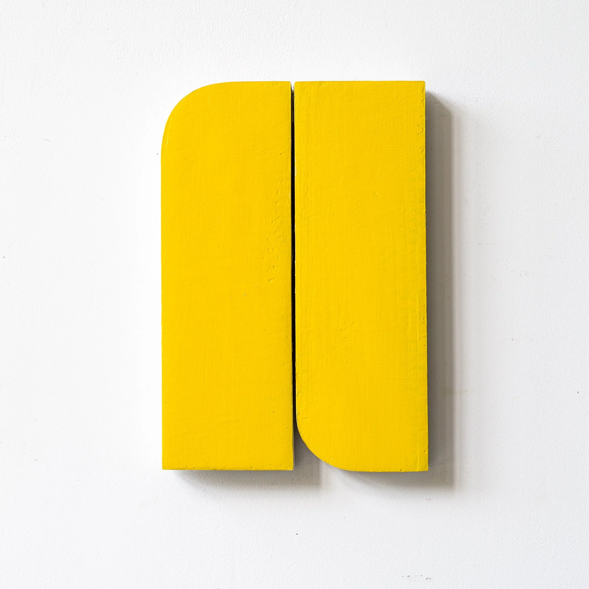 SOLD

Two vertical yellow cardboard panels, each with one corner rounded, positioned side by side on a white wall.