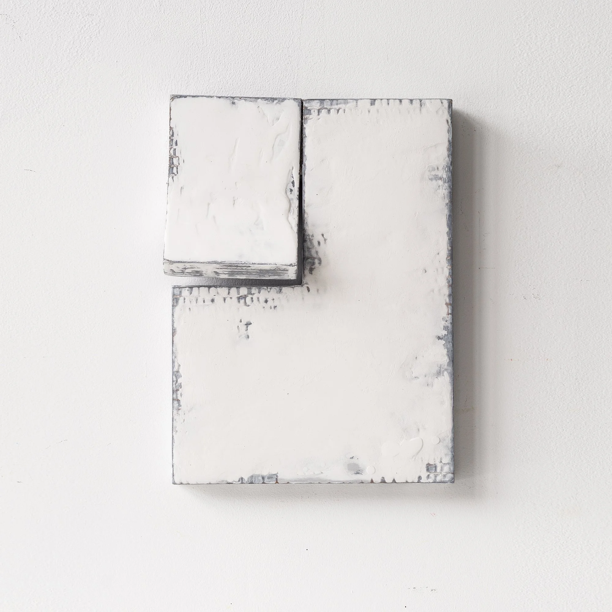 SOLD

Abstract white rectangular sculpture with textured surfaces, mounted on a wall.